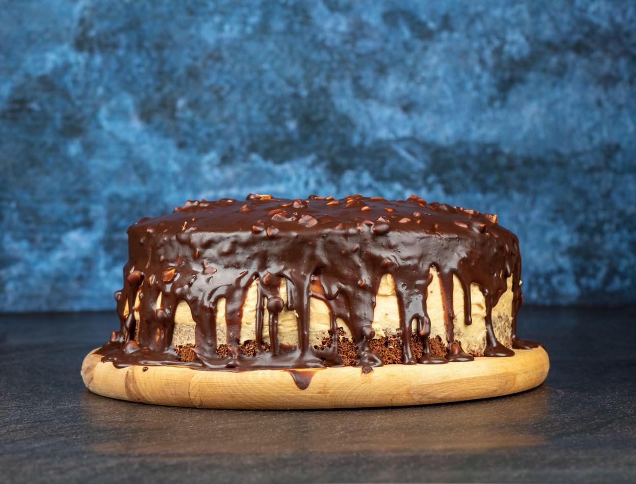 Homemade chocolate biscuit cake on a round cutting board. Copy space. Home cooking.
