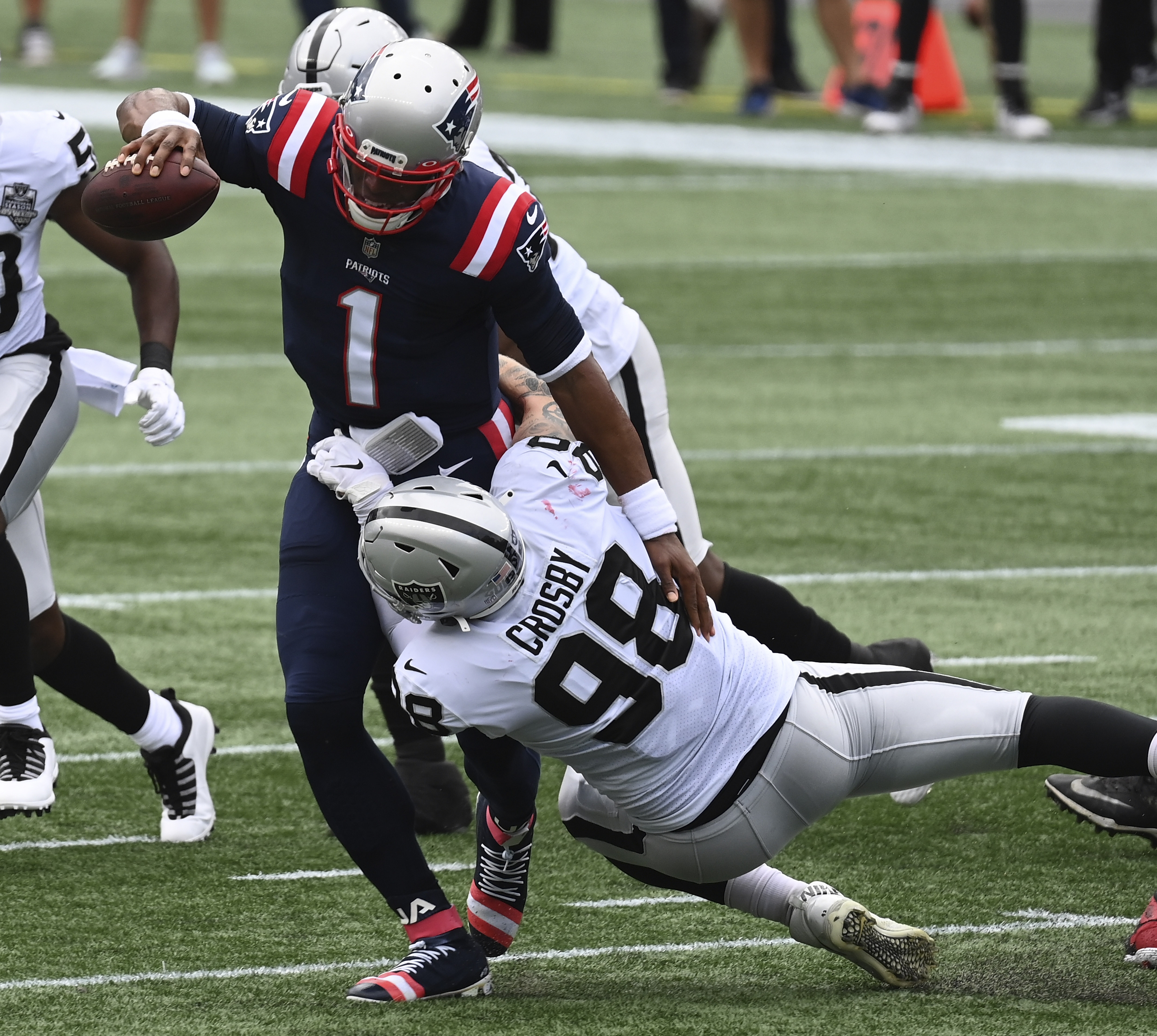 epa08702500 New England Patriots quarterback Cam Newton (L) is tackled by Las Vegas Raiders defensive end Maxx Crosby (R) during the first half at Gillette Stadium in Foxborough, Massachusetts, USA, 27 September 2020.  EPA-EFE/JOHN CETRINO