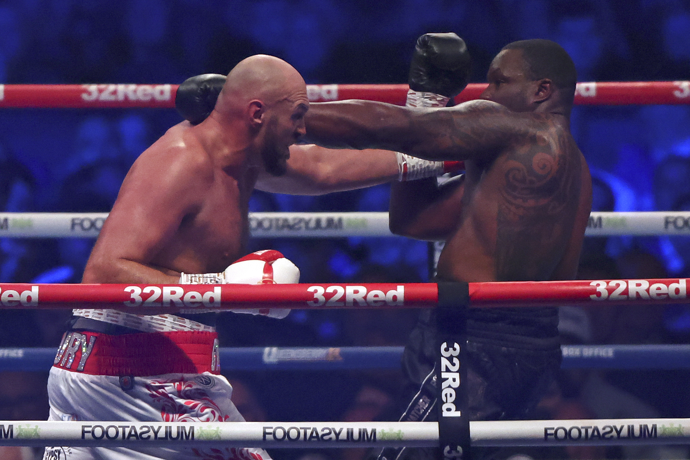 Britain's Tyson Fury, left, lands a blow on Britain's Dillian Whyte during their WBC heavyweight title boxing fight at Wembley Stadium in London, Saturday, April 23, 2022. (AP Photo/Ian Walton)