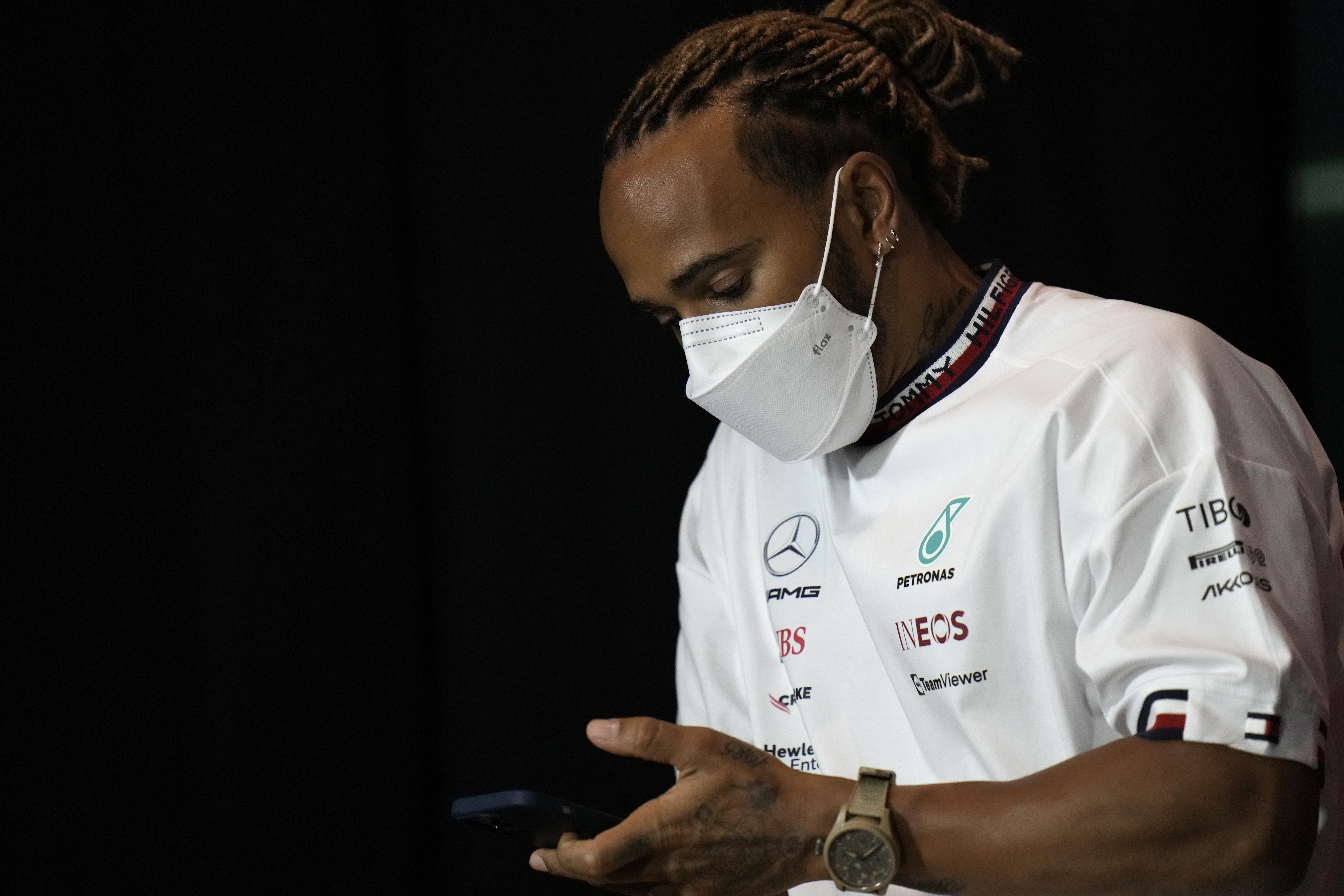 Mercedes driver Lewis Hamilton of Britain checks his mobile phone during a press conference at the Jiddah corniche circuit in Jiddah, Saudi Arabia, Friday, March 25, 2022. (AP Photo/Hassan Ammar)