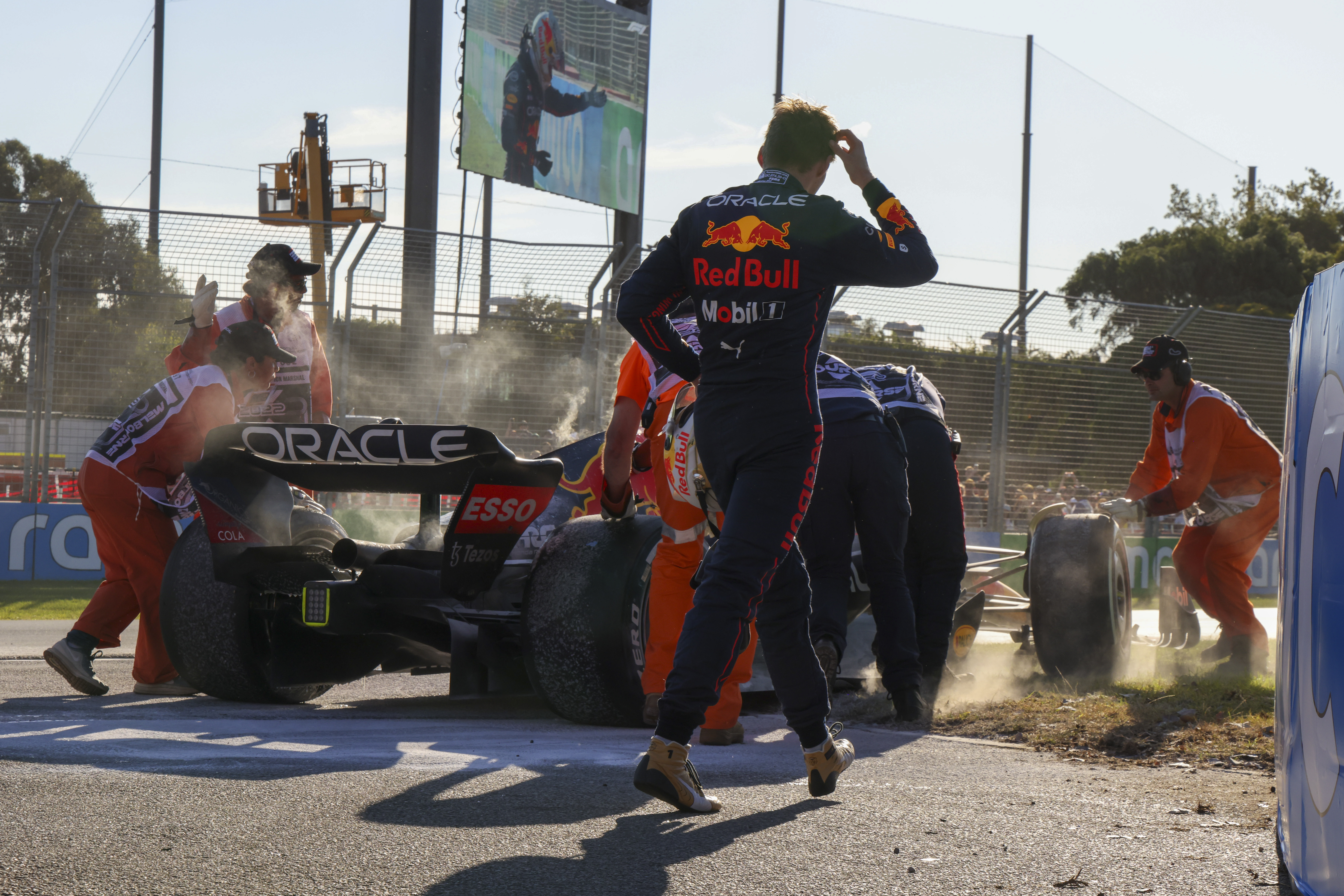 Red Bull driver Max Verstappen of the Netherlands watches as track marshals push his car from the circuit after he withdrew from the Australian Formula One Grand Prix in Melbourne, Australia, Sunday, April 10, 2022. (AP Photo/Asanka Brendon Ratnayake)