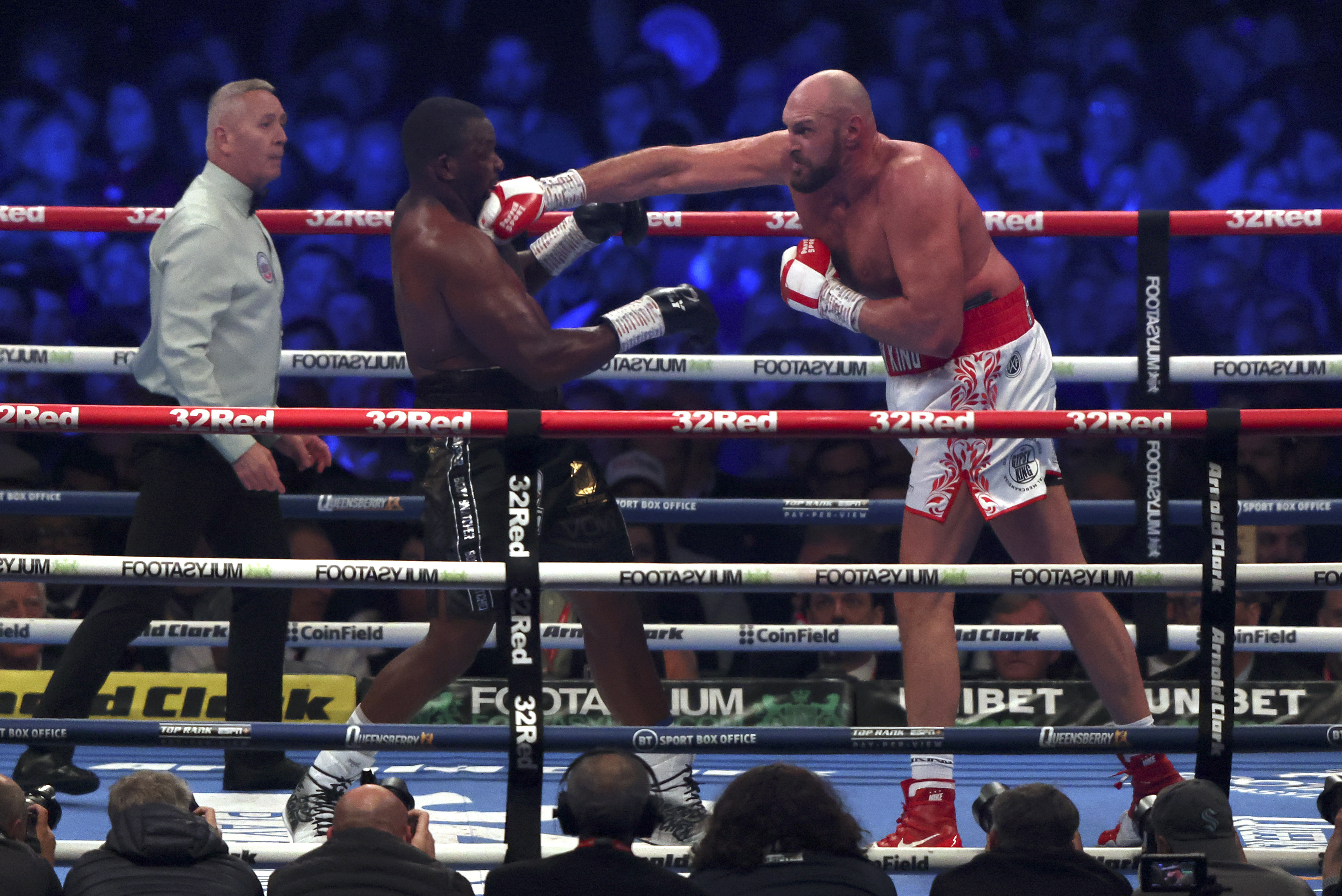 Britain's Tyson Fury, right, lands a blow on Britain's Dillian Whyte during their WBC heavyweight title boxing fight at Wembley Stadium in London, Saturday, April 23, 2022. (AP Photo/Ian Walton)