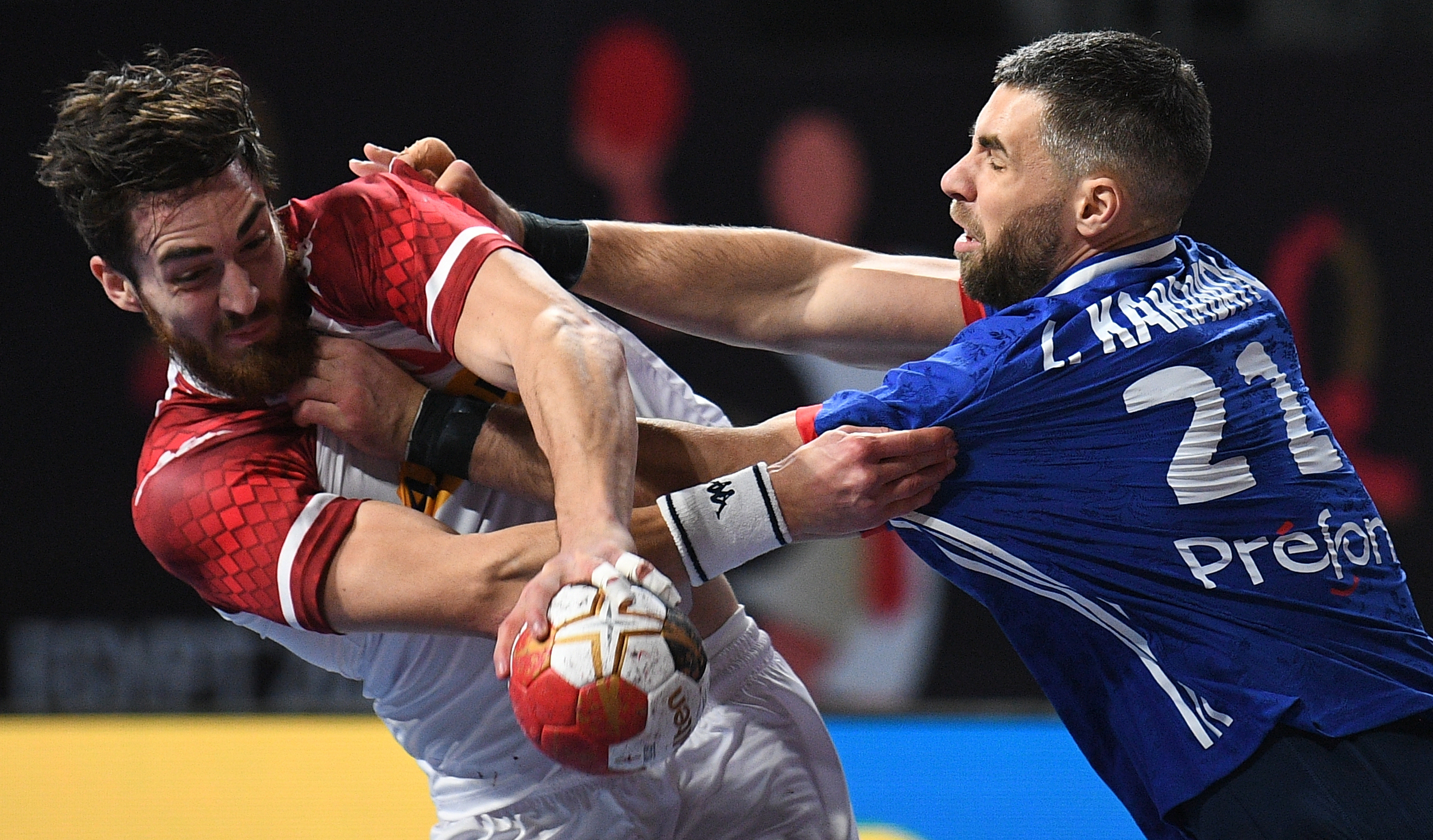 epa08942356 Austria's Boris Zivkovic (L) in action against France's Luka Karabatic (R) during the match between Austria and France at the 27th Men's Handball World Championship in Cairo, Egypt, 16 January 2021.  EPA-EFE/Anne-Christine Poujoulat / POOL
