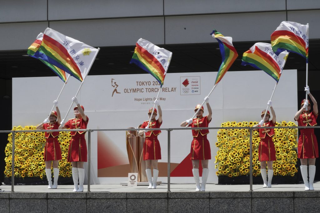 Tokyo Fire Department performers wave their flags shortly before the torch relay for Tokyo Olympics concludes at the Tokyo Metropolitan Government complex in Tokyo Friday, July 23, 2021. (AP Photo/Kantaro Komiya)