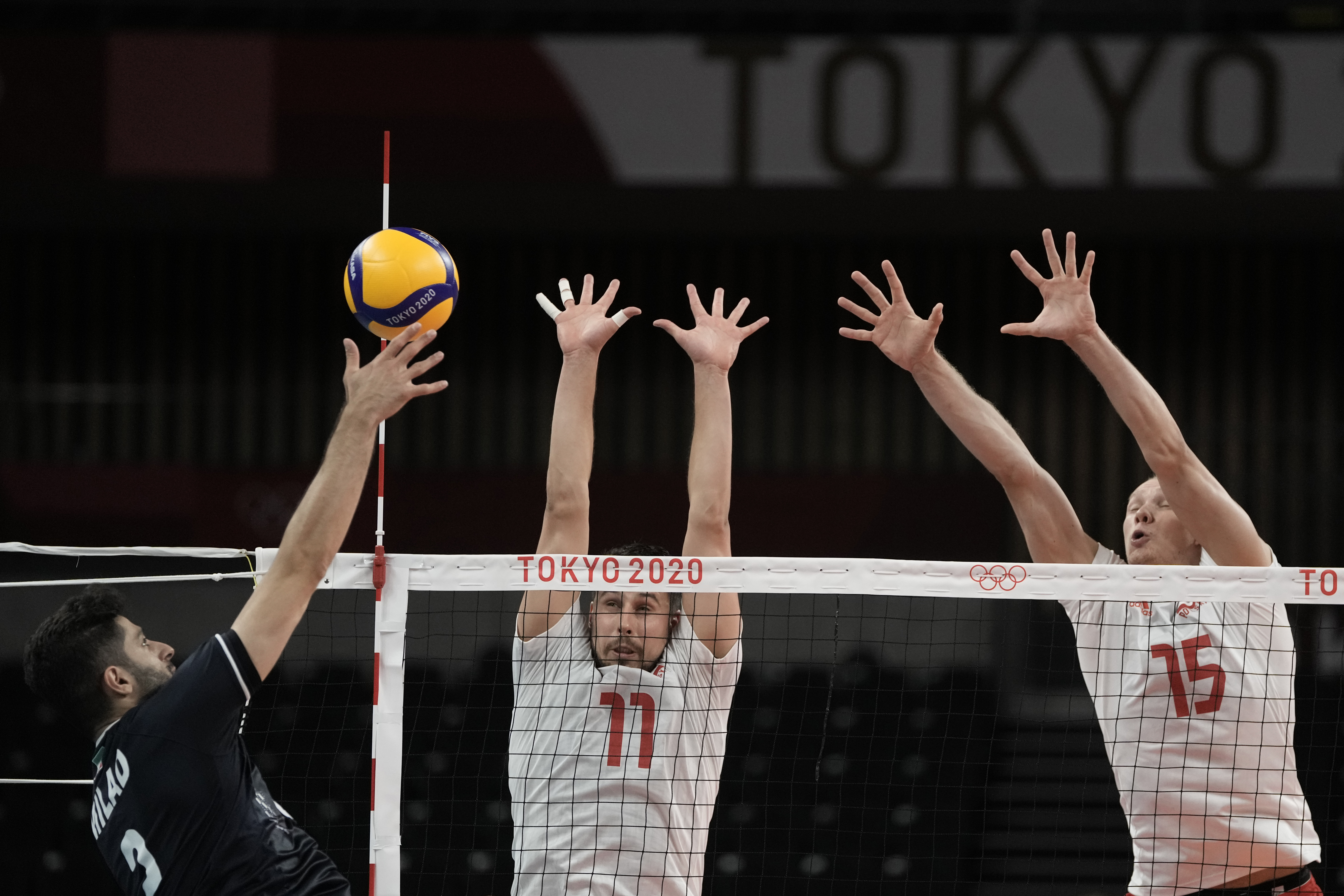 Poland's Fabian Drzyzga and Jakub Kochanowski defend against a spiked ball during a men's volleyball preliminary round pool A match against Iran, at the 2020 Summer Olympics, Saturday, July 24, 2021, in Tokyo, Japan. (AP Photo/Manu Fernandez)