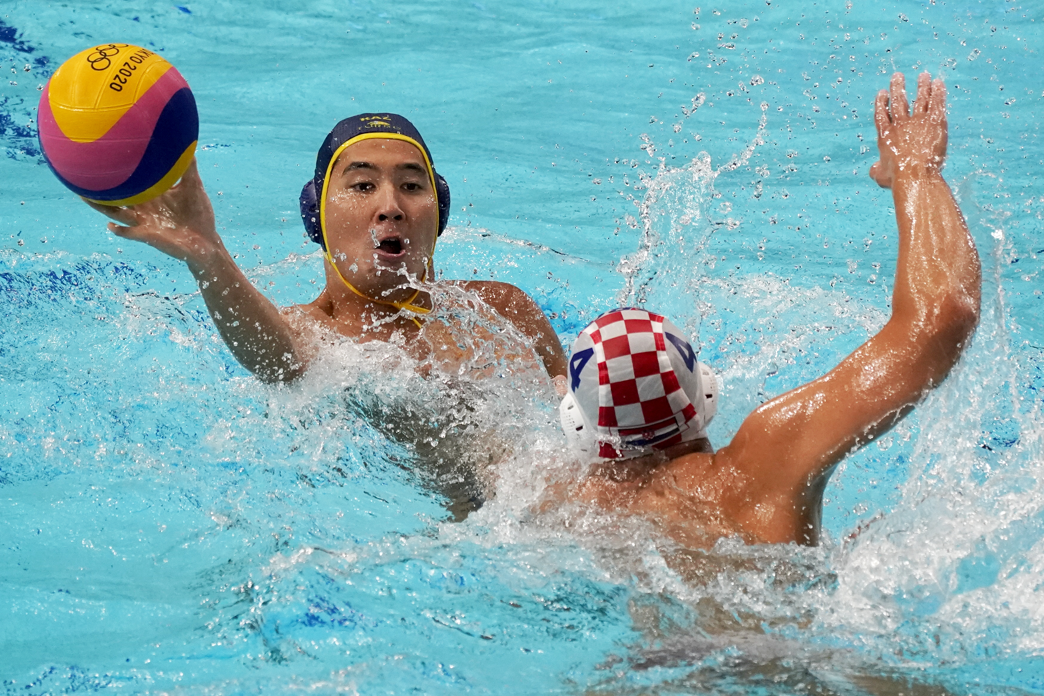Kazakhstan's Rustam Ukumanov, left, is pressured by Croatia's Luka Loncar (4) during a preliminary round men's water polo match at the 2020 Summer Olympics, Sunday, July 25, 2021, in Tokyo, Japan. (AP Photo/Mark Humphrey)