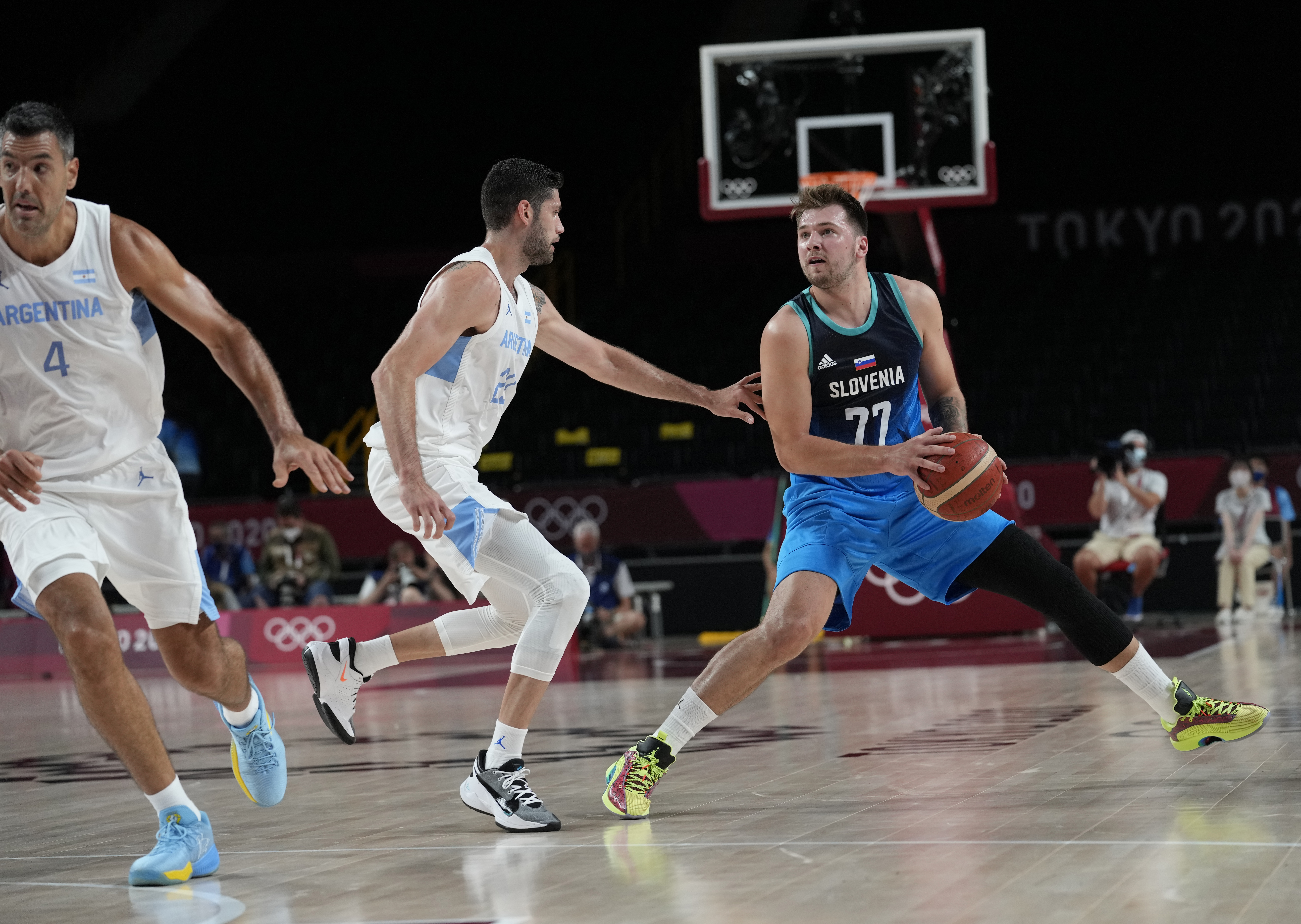 Slovenia's Luka Doncic (77), right, drives to the basket during men's basketball preliminary round game against Argentina at the 2020 Summer Olympics, Monday, July 26, 2021, in Saitama, Japan. (AP Photo/Eric Gay)