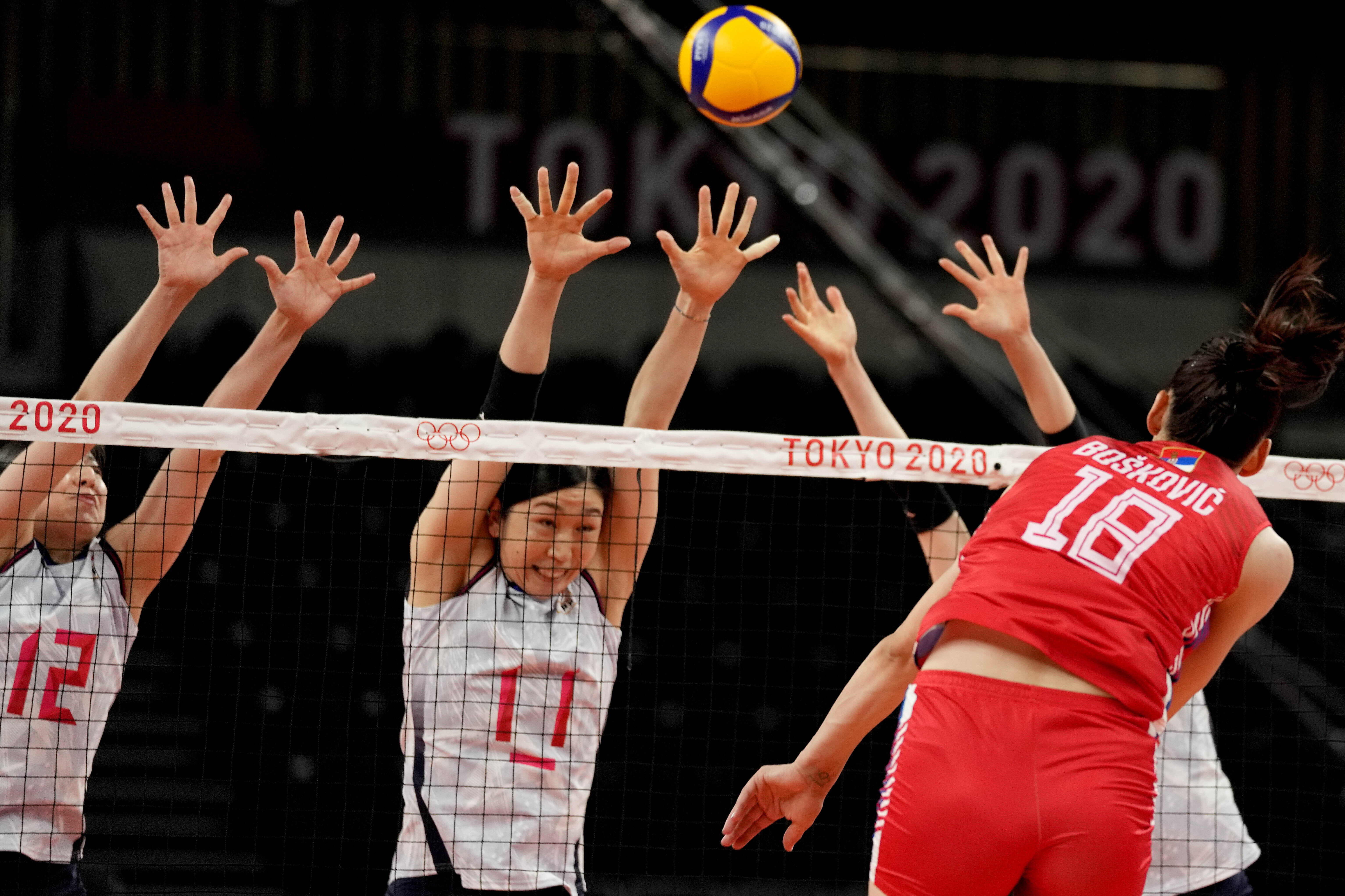 Serbia's Tijana Boskovic hits the ball past the Japan block during the women's volleyball preliminary round pool A match between Japan and Serbia at the 2020 Summer Olympics, Tuesday, July 27, 2021, in Tokyo, Japan. (AP Photo/Frank Augstein)