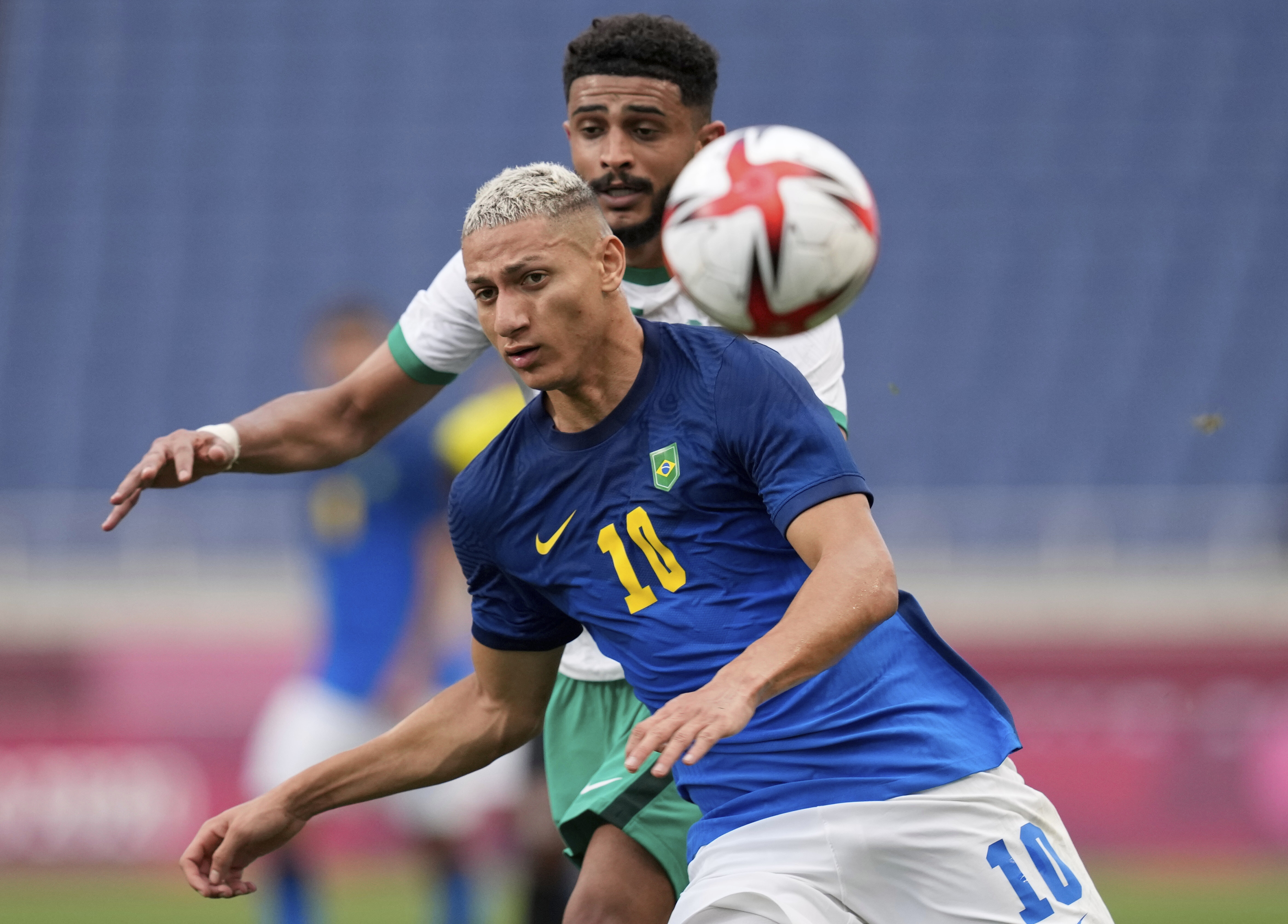 Brazil's Richarlison, front, and Saudi Arabia's Abdulelah Alamri battle for the ball during a men's soccer match at the 2020 Summer Olympics, Wednesday, July 28, 2021, in Saitama, Japan. (AP Photo/Martin Mejia)