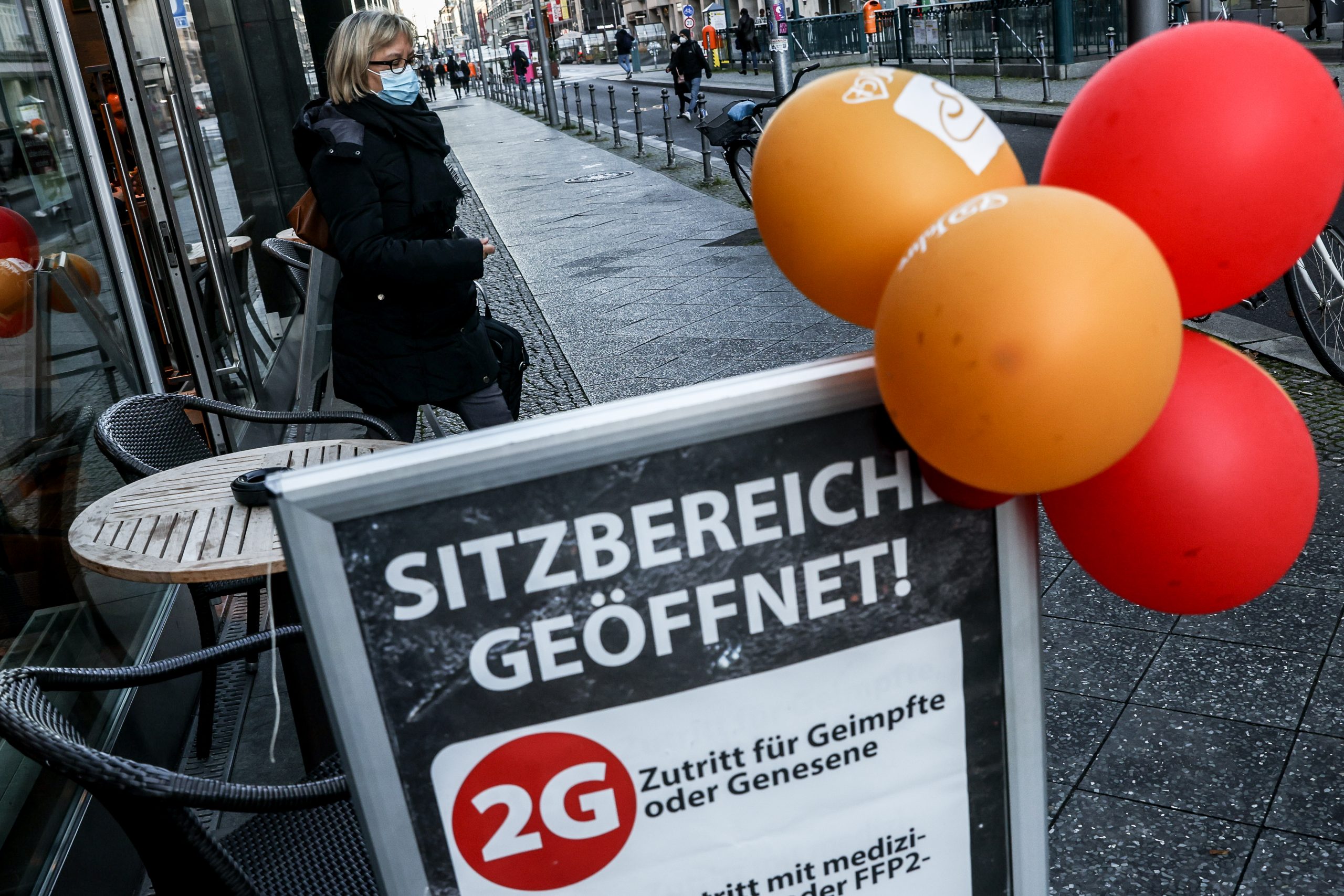 epaselect epa09597281 A woman wears a face mask as she walks in the Berlin city center, Germany, 22 November 2021. Germany is dealing with a high number of new Sars-CoV-2 infections.  EPA-EFE/FILIP SINGER