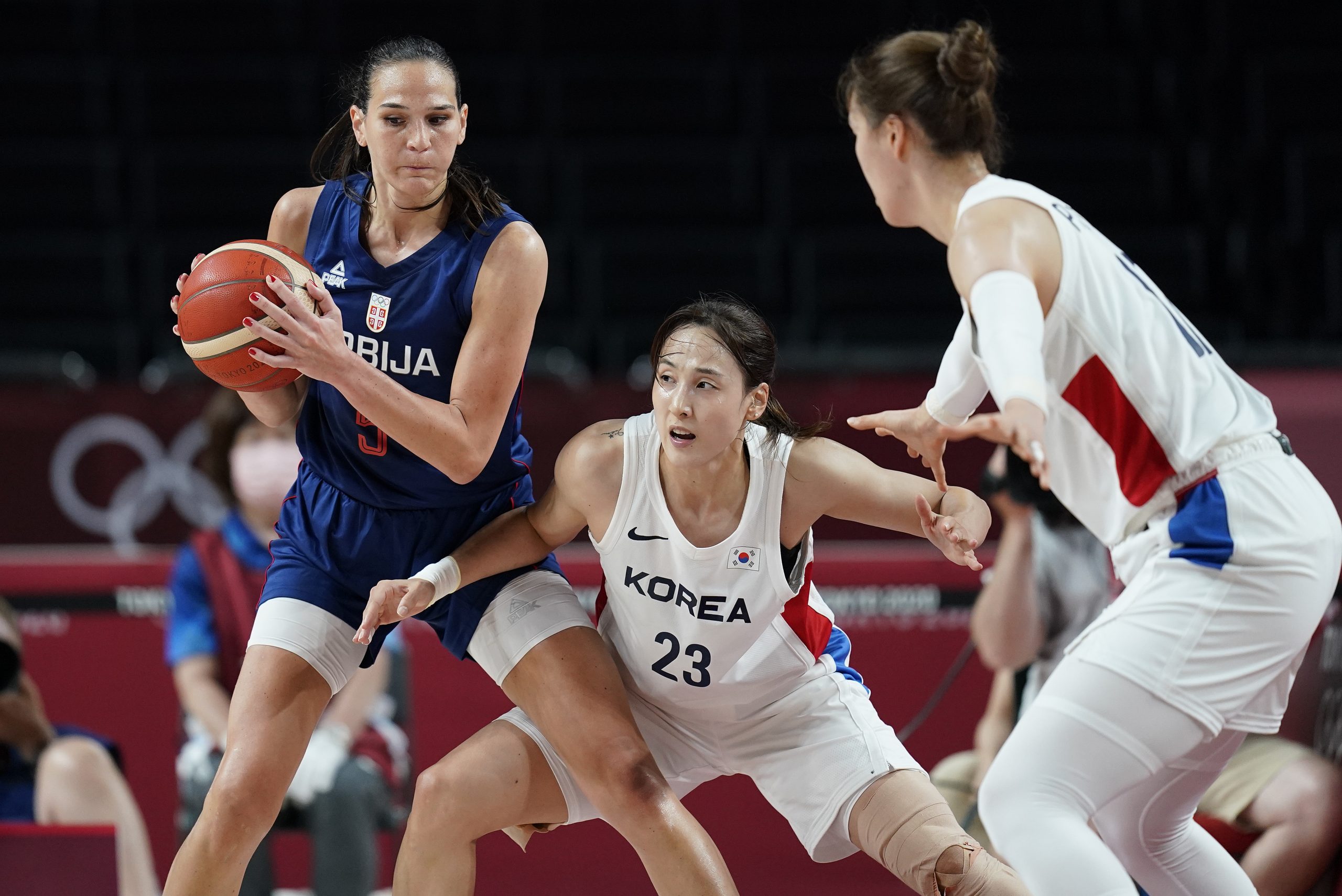 Serbia's Sonja Vasic (5) looks to pass around South Korea's Danbi Kim (23) during a women's preliminary round basketball game at the 2020 Summer Olympics, Sunday, Aug. 1, 2021, in Saitama, Japan. (AP Photo/Charlie Neibergall)