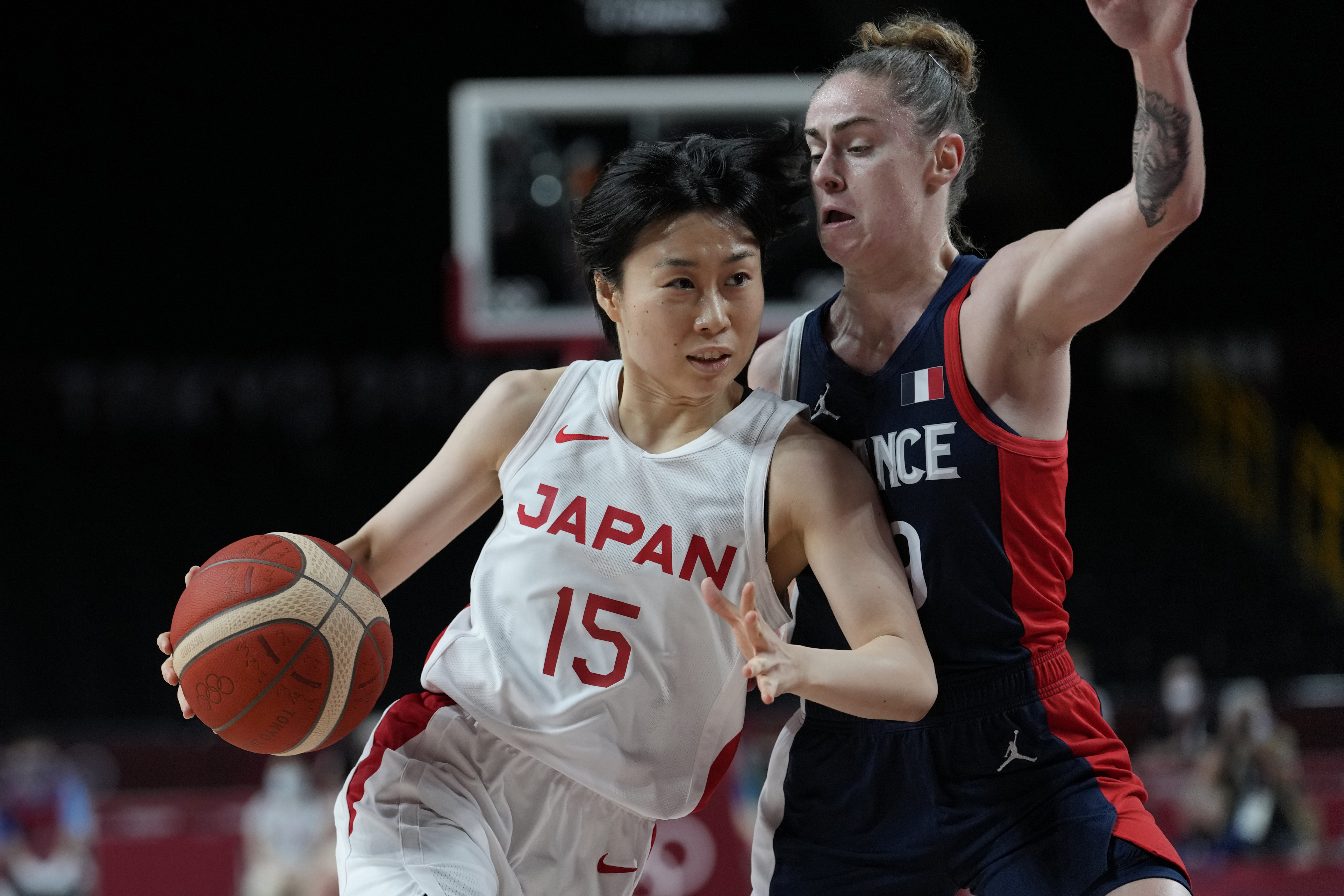 Japan's Nako Motohashi (15) drives around France's Alix Duchet (39) during a women's semifinal basketball game at the 2020 Summer Olympics, Friday, Aug. 6, 2021, in Saitama, Japan. (AP Photo/Eric Gay)