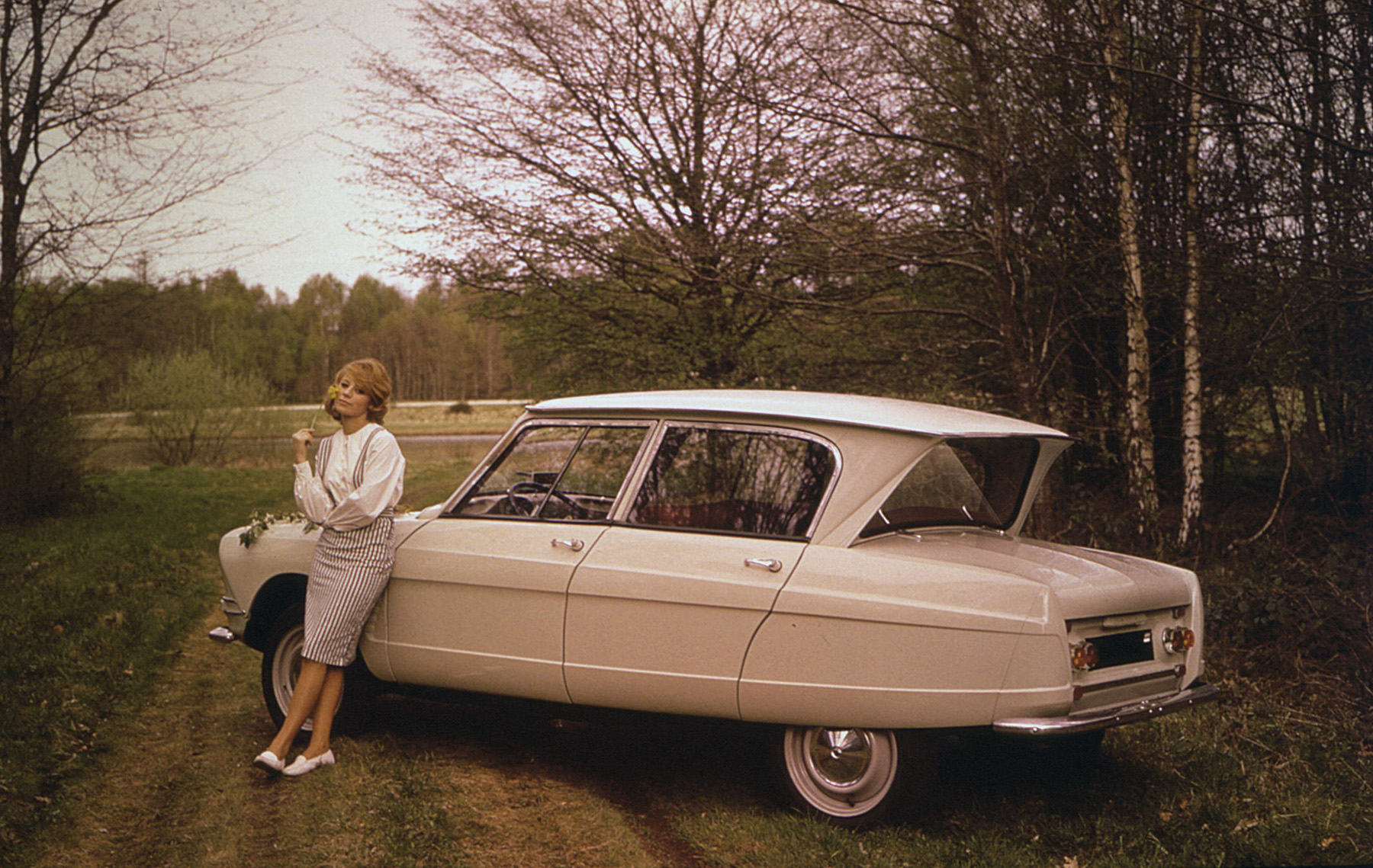 Image Exclusive * Femme posant contre une Citroën Ami 6 garée sur un chemin de forêt en 1961. Photo de Georges Guyot. Utilisation éditoriale uniquement, nous contacter pour toute autre utilisation