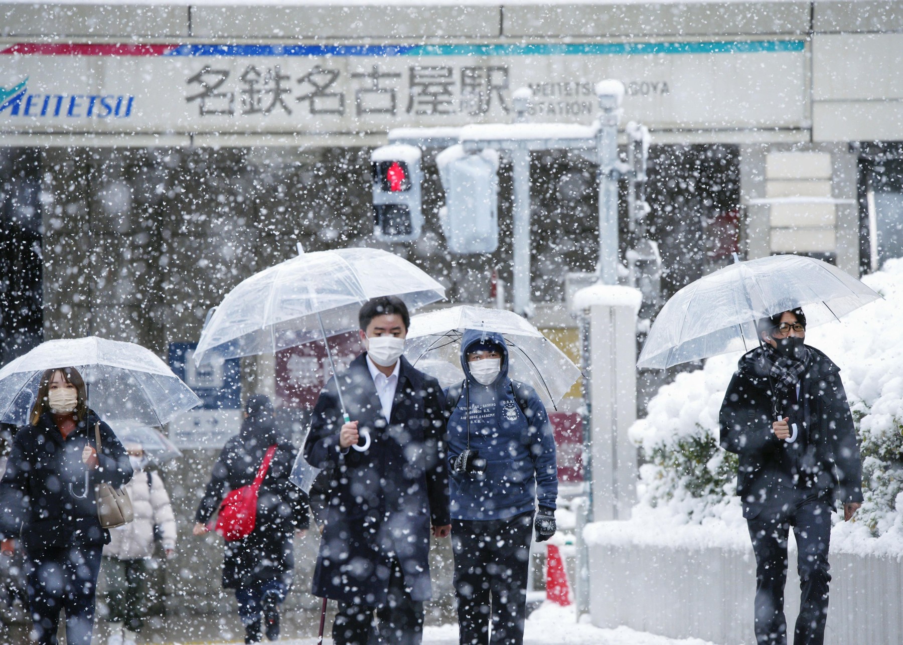 People walk in the snow in front of Nagoya Station in central Japan on Dec. 27, 2021.,Image: 649480010, License: Rights-managed, Restrictions: , Model Release: no, Credit line: Kyodo/Newscom / Newscom / Profimedia
