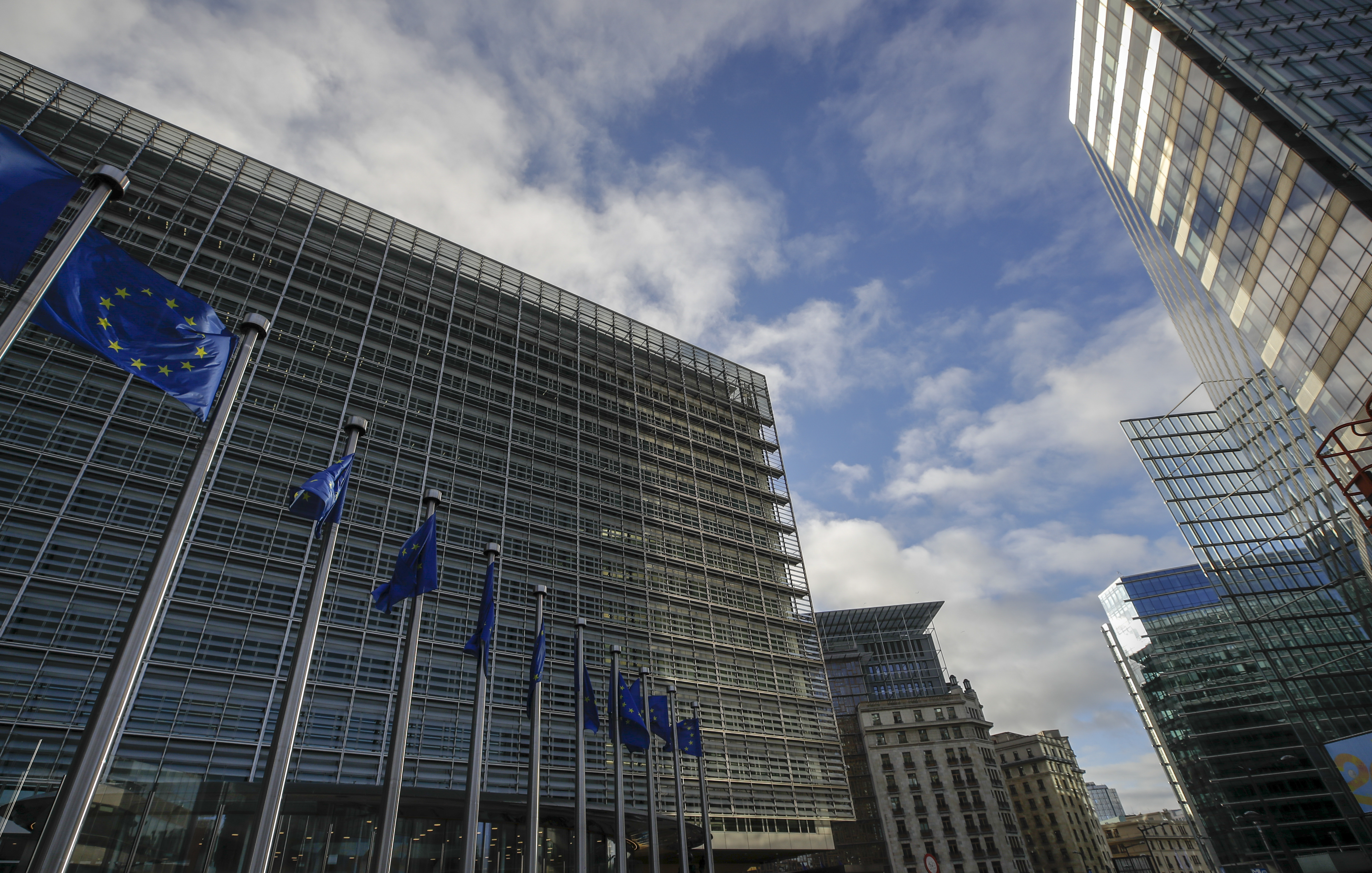 epa09629196 Outside view of European Commission headquarters called Berlaymont and EU flags and in background European Council Europa buildings in Brussels, Belgium, 08 December 2021.  EPA-EFE/OLIVIER HOSLET
