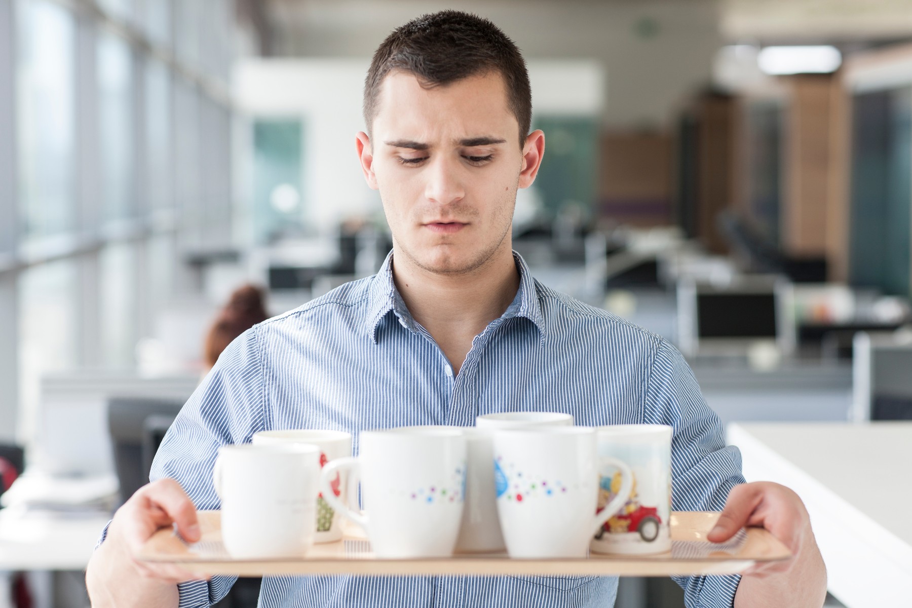Nervous looking man carrying tray of mugs moja prva plata