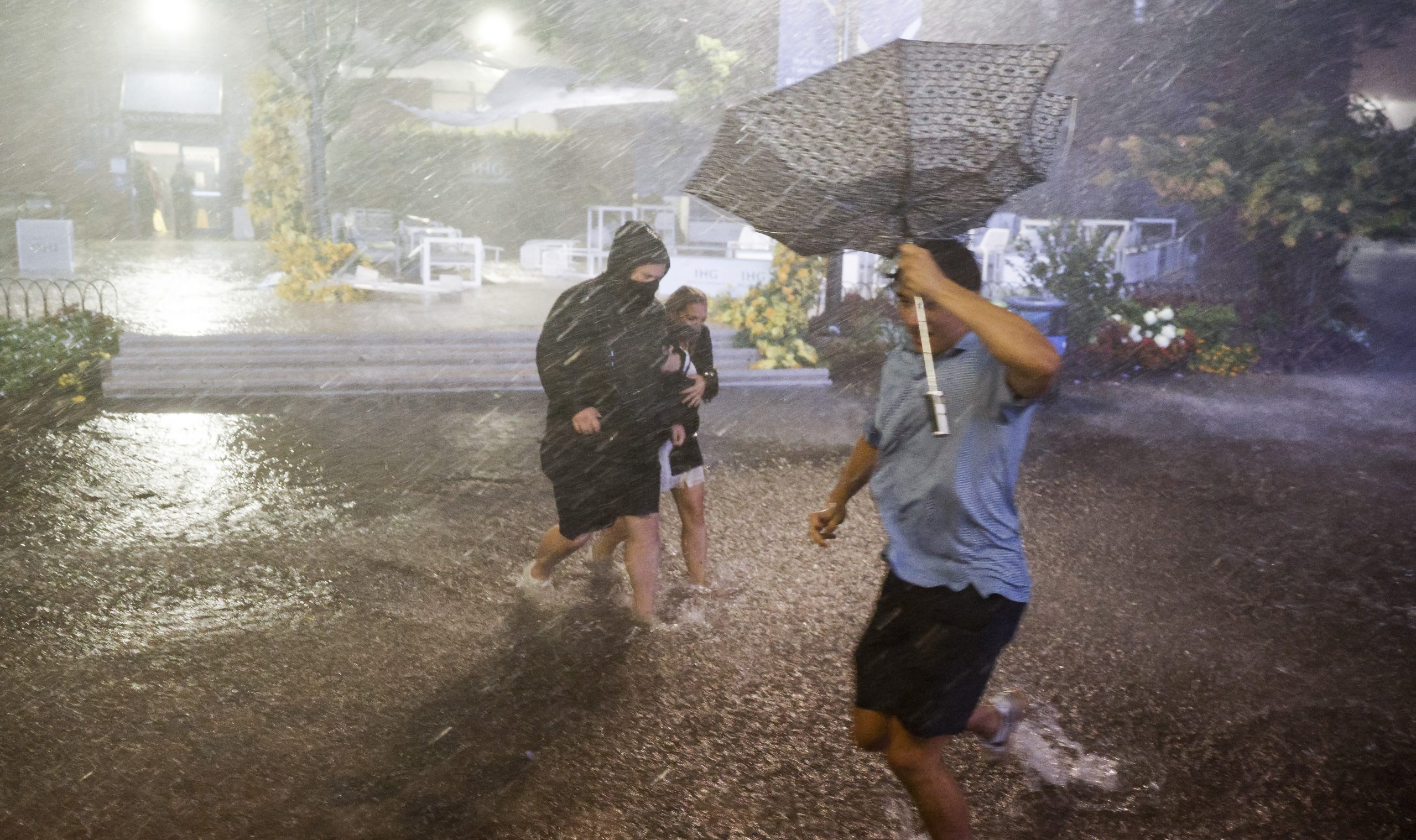 epa09442067 People navigate heavy rains and flooded walkways at the Billie Jean King National Tennis Center as the remnants of Hurricane Ida hit the area in Flushing Meadows, New York, USA, 01 September 2021.  EPA-EFE/JUSTIN LANE