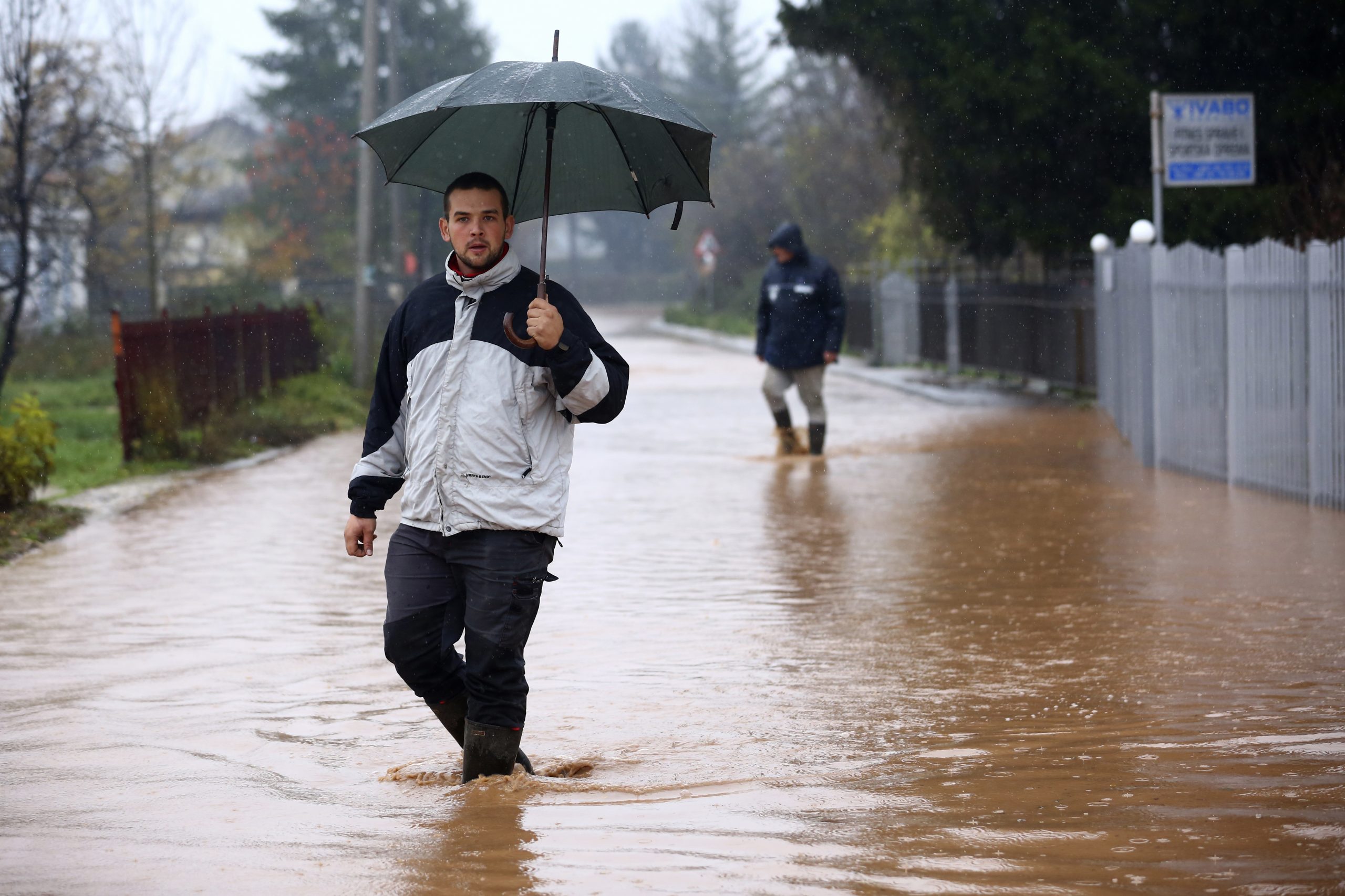 Men wade through a flooded street in the Sarajevo suburb of Ilidza, Bosnia, Friday, Nov. 5, 2021. Heavy rain has caused flash flooding in Bosnia, prompting evacuations and submerging local roads in some parts of the country on Friday. (AP Photo)