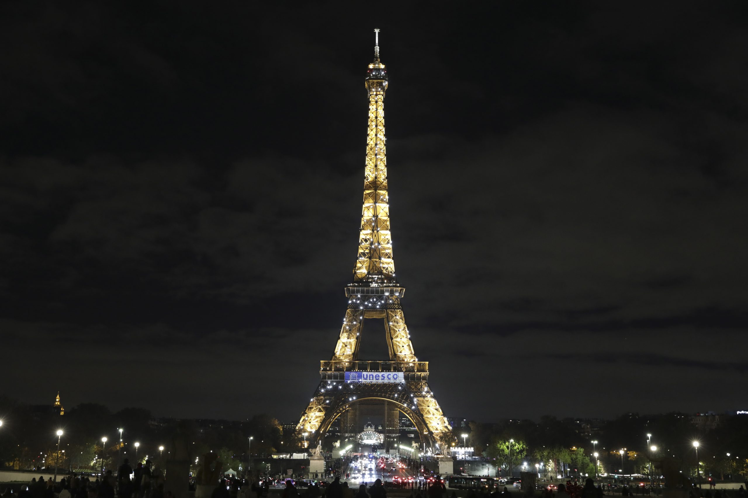 The Eiffel Tower bears the UNESCO logo to celebrate the 75th anniversary of the United Nations Educational, Scientific and Cultural Organization (UNESCO), in Paris ,Friday Nov. 12, 2021. (AP Photo/Adrienne Surprenant)