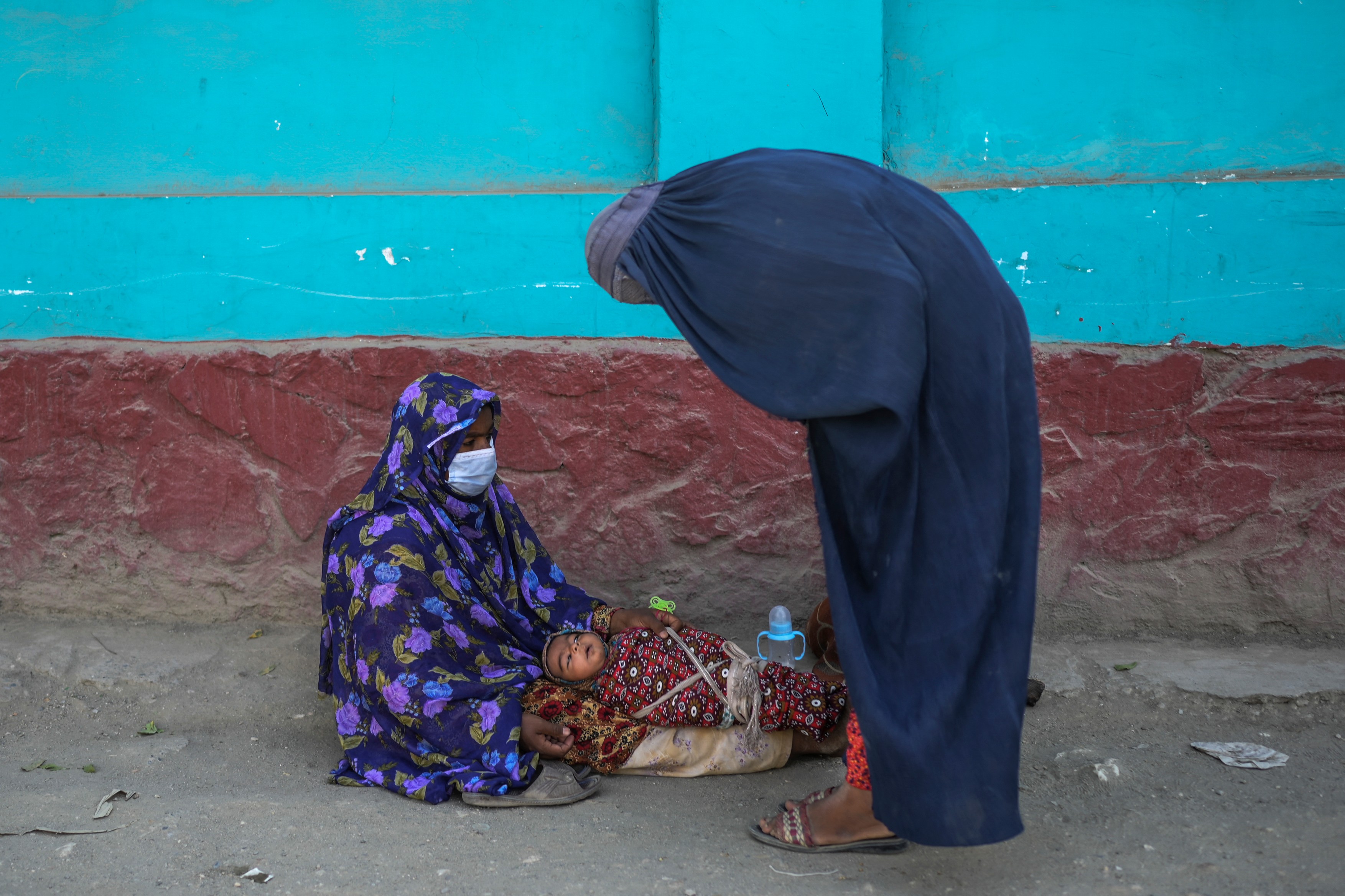 A burqa-clad woman (R) checks on a beggar with a baby sitting along a street in Kabul on September 15, 2021.,Image: 632277568, License: Rights-managed, Restrictions: , Model Release: no, Credit line: BULENT KILIC / AFP / Profimedia