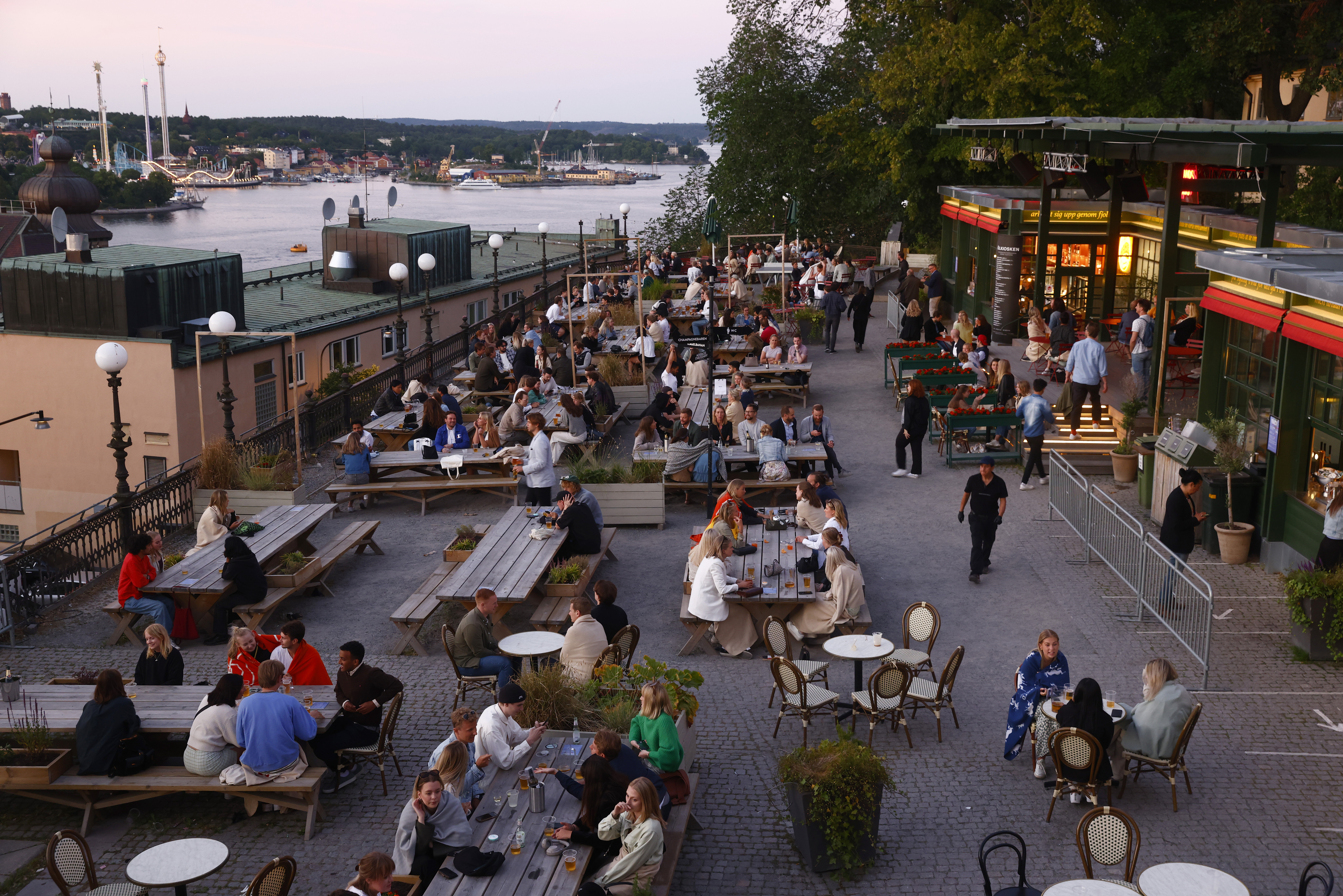epa09316645 People sit at the tables at an outdoor bar in Stockholm, Sweden, 01 July 2021. The restrictions for opening hours at restaurants and bars have been removed completely on 01 Jyly.  EPA-EFE/Stefan Jerrevang SWEDEN OUT