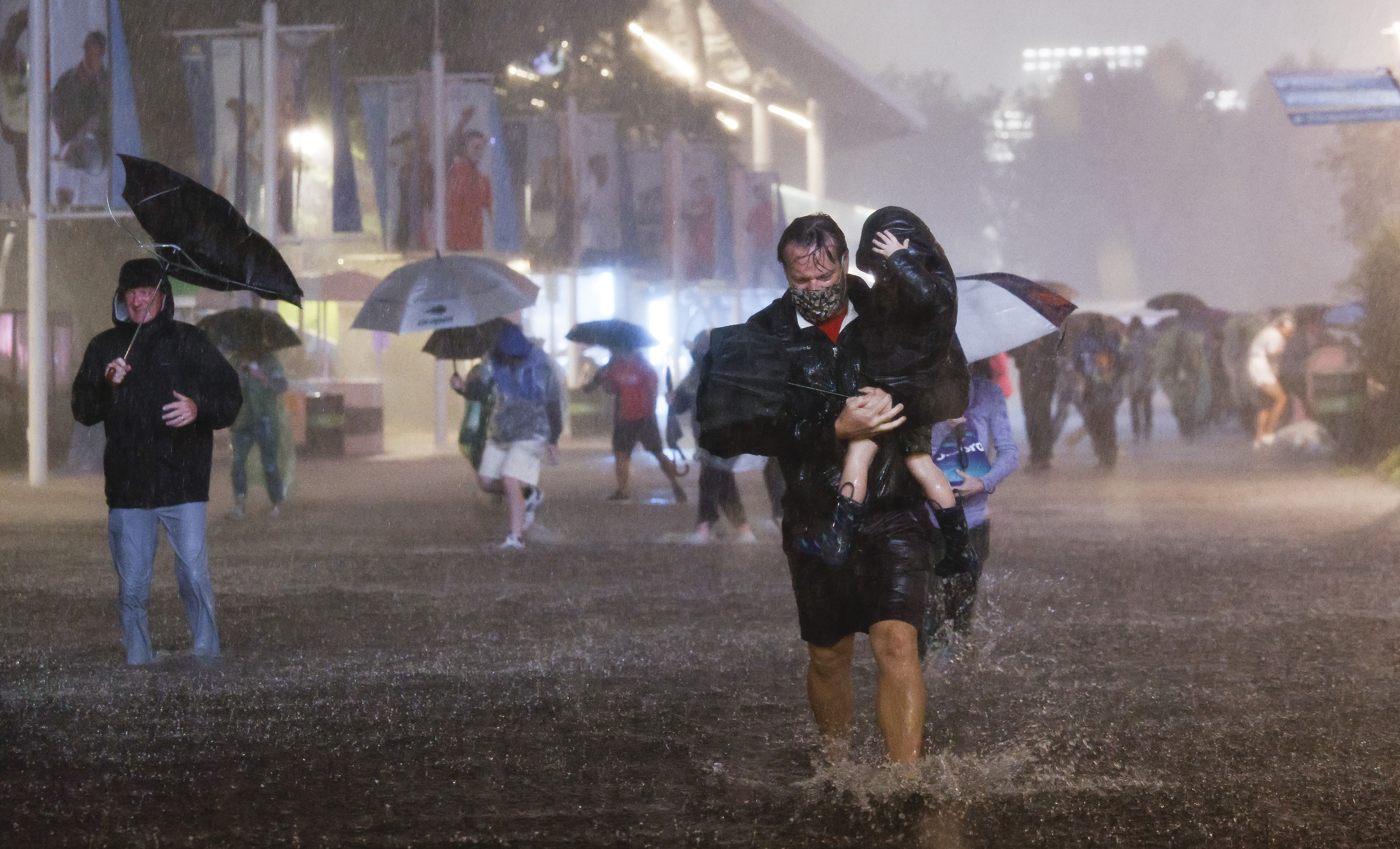 epa09442066 People navigate heavy rains and flooded walkways at the Billie Jean King National Tennis Center as the remnants of Hurricane Ida hit the area in Flushing Meadows, New York, USA, 01 September 2021.  EPA-EFE/JUSTIN LANE