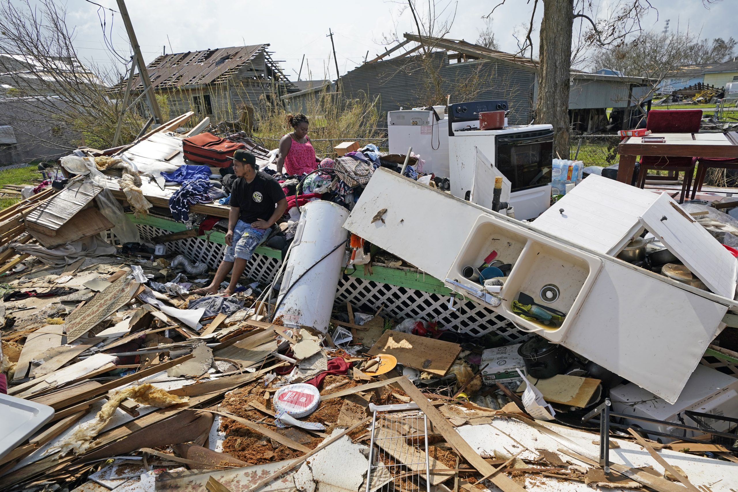 Cruz Palma, right, and her son Jose Duran sit in what remains of her home in the aftermath of Hurricane Ida, Thursday, Sept. 2, 2021, in Golden Meadow, La. (AP Photo/David J. Phillip)