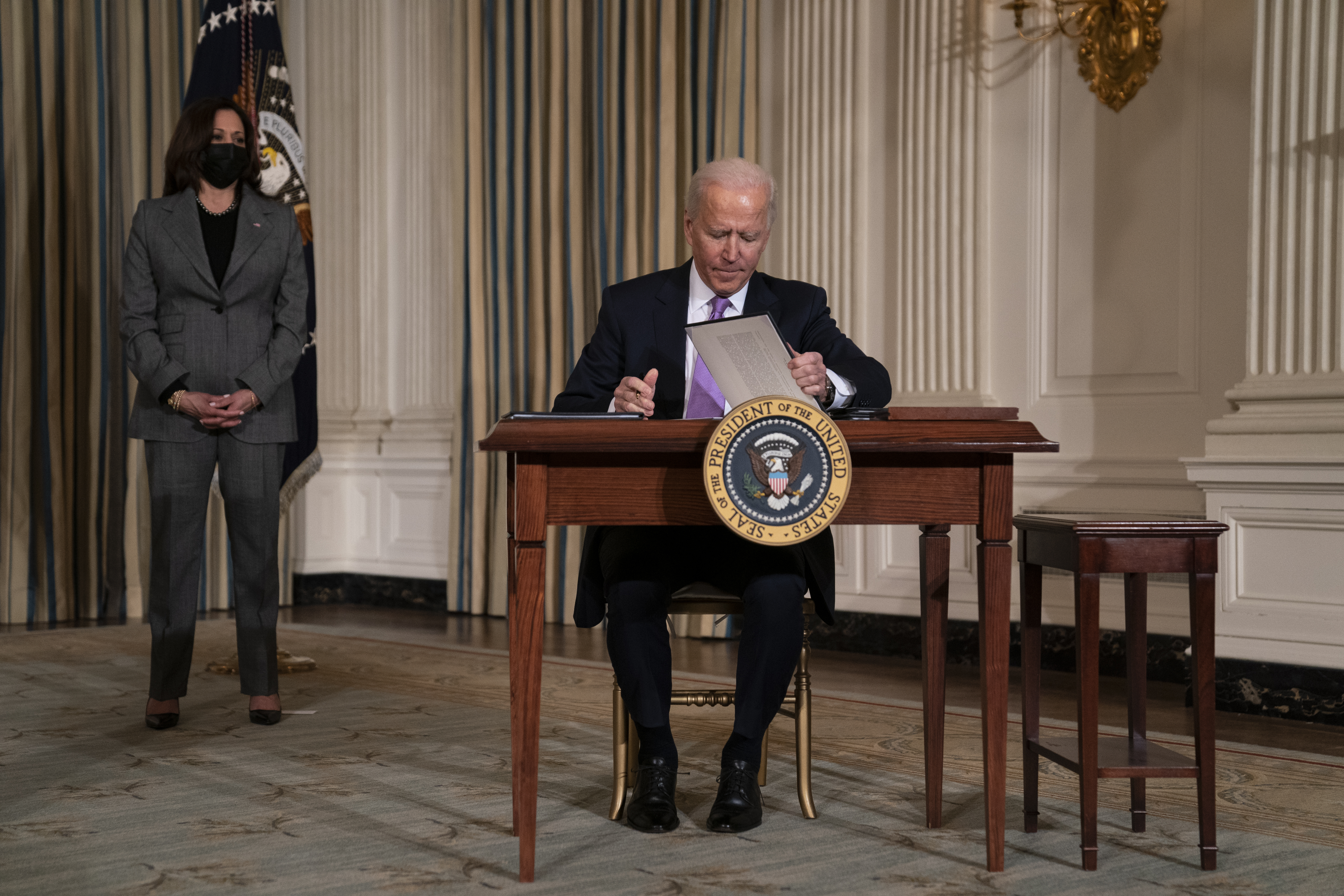 Vice President Kamala Harris looks on as President Joe Biden signs a series of executive orders on racial equity, in the State Dining Room of the White House, Tuesday, Jan. 26, 2021, in Washington. (AP Photo/Evan Vucci)