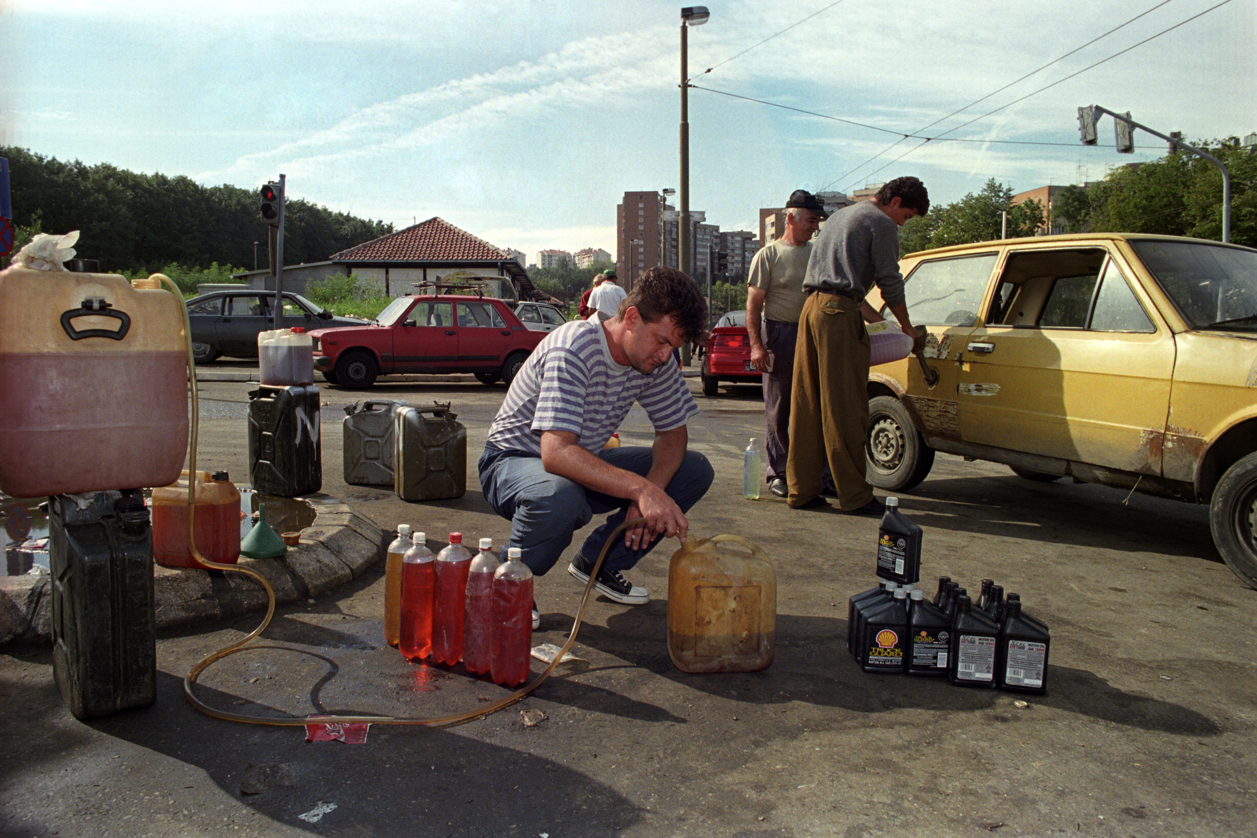 A man fills the can with the petrol at the street market in Belgrade suburbs, Yugoslavia, 10 June 1994. EPA/MILOS VUKADINOVIC
