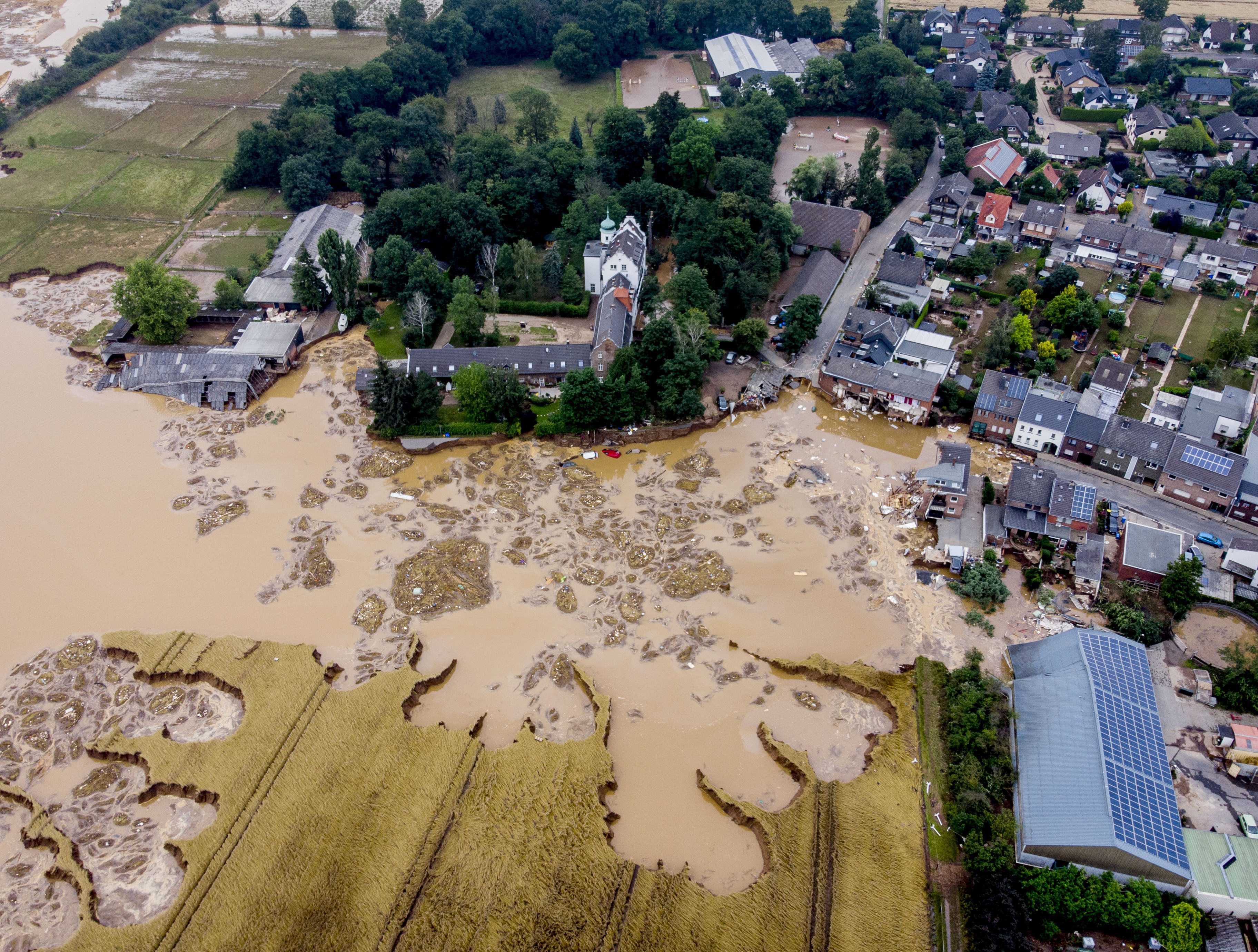A damaged castle, left, is seen in Erftstadt-Blessem, Germany, Saturday, July 17, 2021. Due to strong rainfall, the small Erft river went over its banks causing massive damage. (AP Photo/Michael Probst)