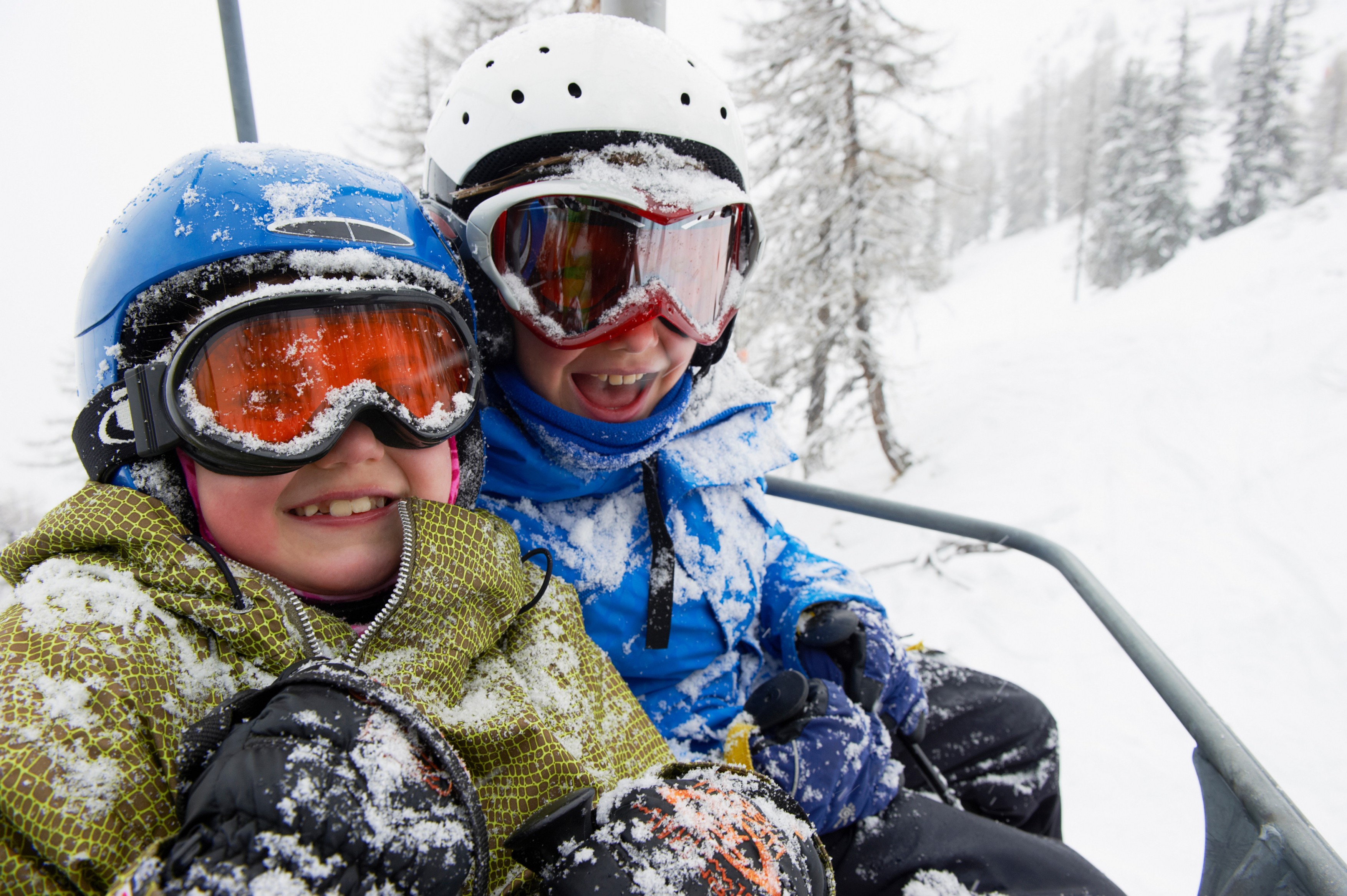 Snow-covered children in ski lift
