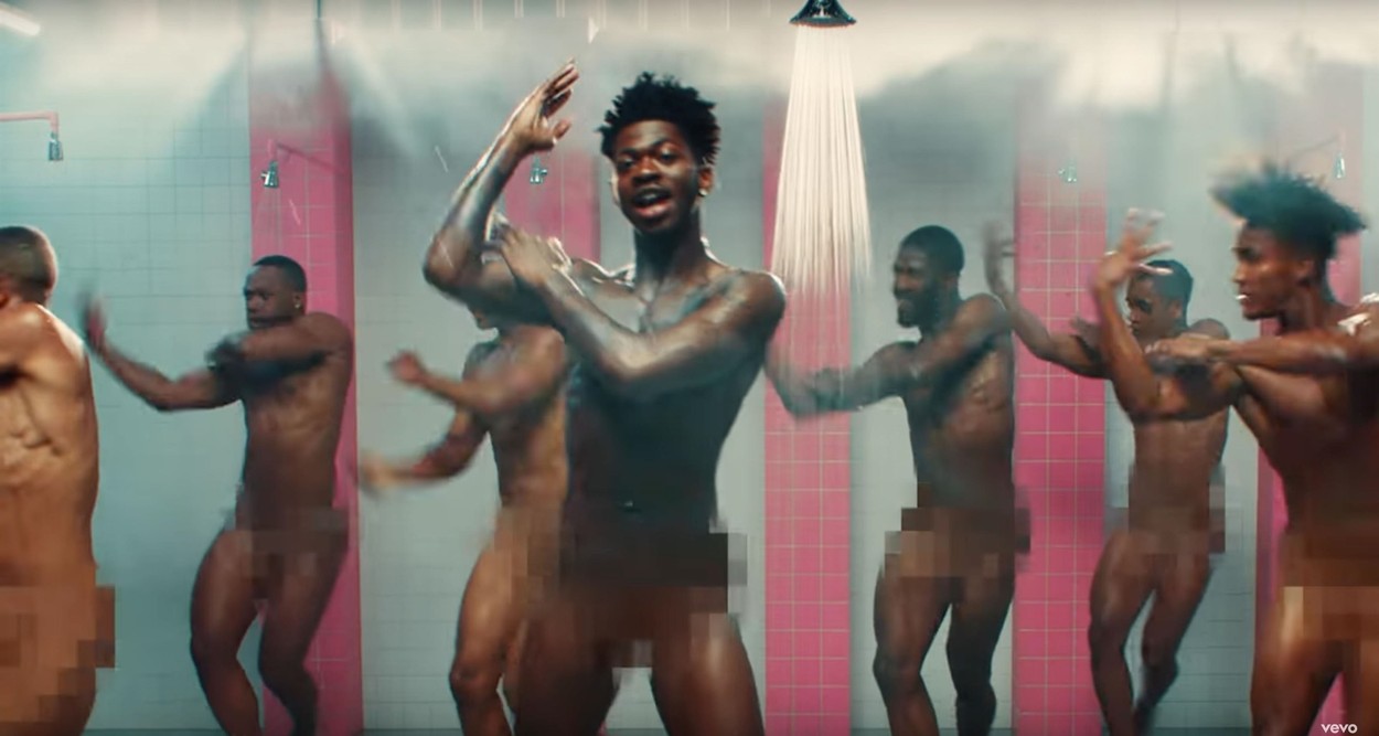 Lil Nas X dances completely naked in a prison shower surrounded by nude male inmates for his latest music video Industry Baby