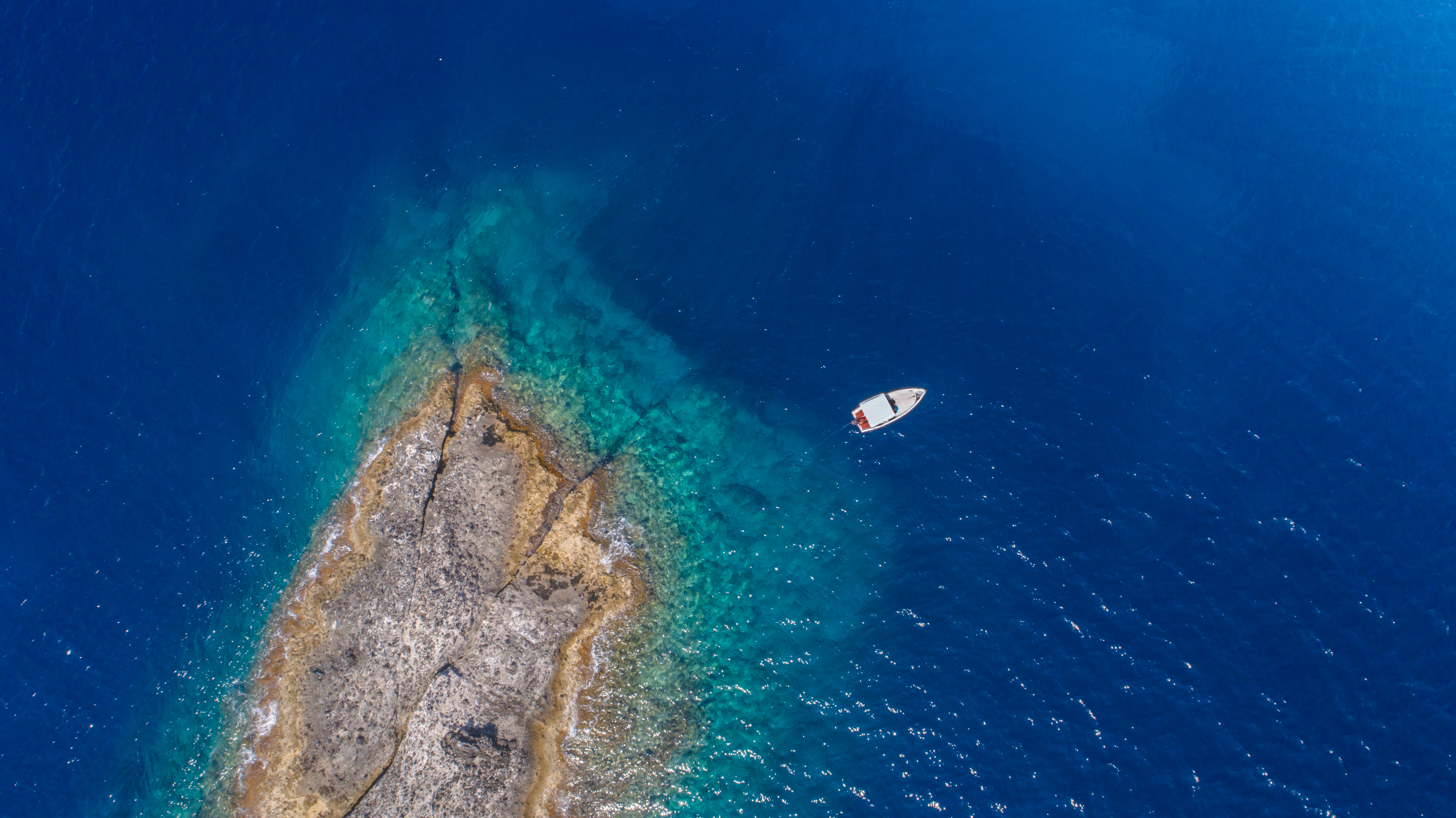 Aerial,Top,View,Of,A,Deserted,Island,With,White,Boat.