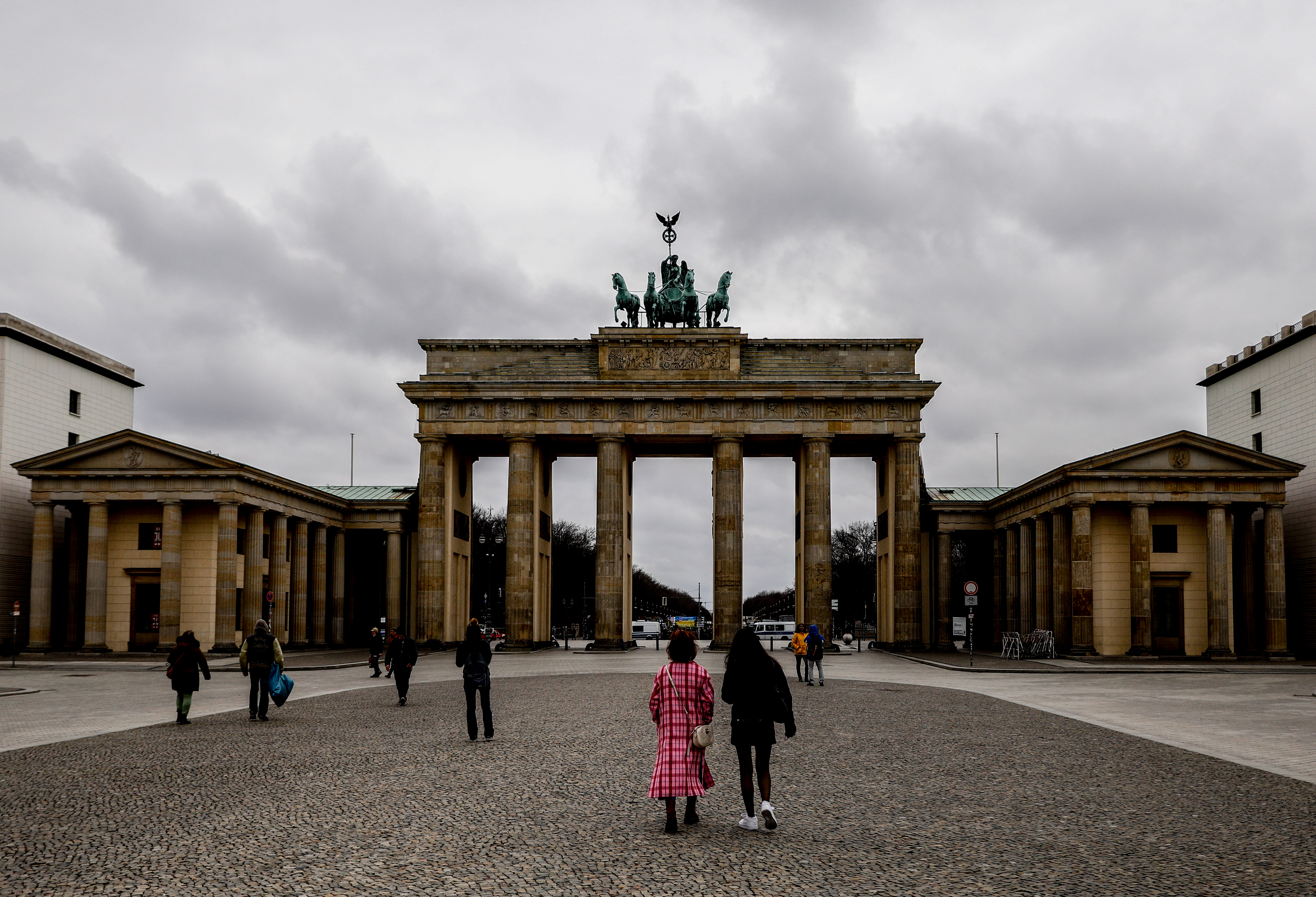 epa09092152 Tourists walks at Pariser Platz with the Brandenburg Gate in the background in Berlin, Germany, 23 March 2021. Germany extended and strengthened its nationwide lockdown measures until 18 April 2021.  EPA-EFE/FILIP SINGER