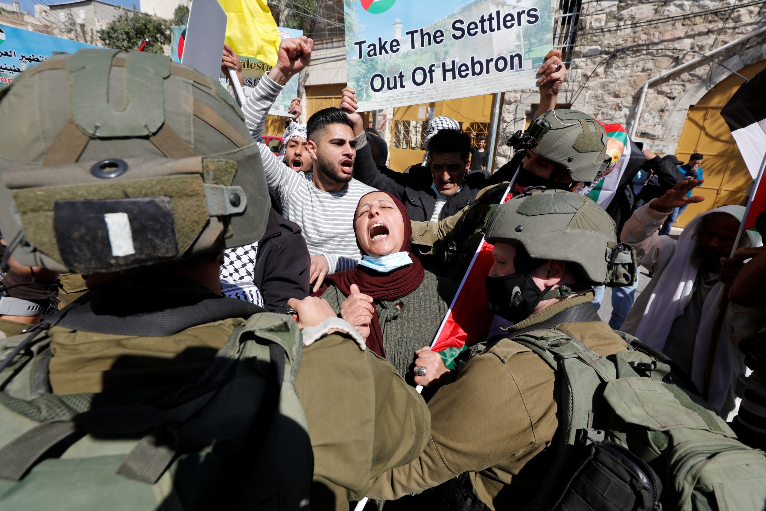 26022021 A Palestinian woman shouts slogans in front of Israeli troops during a protest against Israeli settlers, in Hebron, in the Israeli-occupied West Bank February 26, 2021. REUTERS/Mussa Qawasma