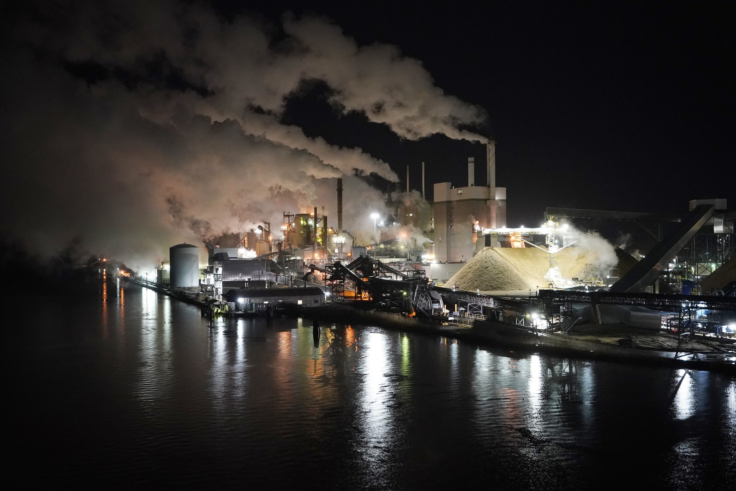 Smoke and steam rise up from the Westrock paper plant along the Pamunkey river in West Point, Va., Friday, Feb. 26, 2021. The mill was opened by the Chesapeake Corporation in 1914. (AP Photo/Steve Helber)