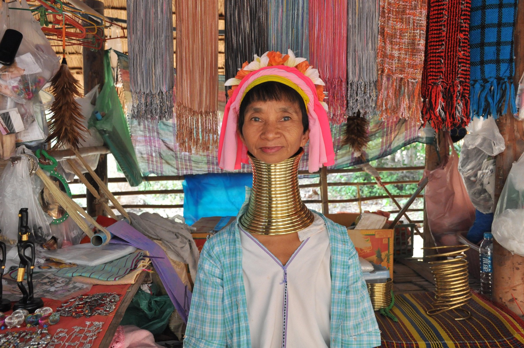 Padaung long-neck woman in front of her souvenir stall in Karen village, Chiang Mai, Thailand