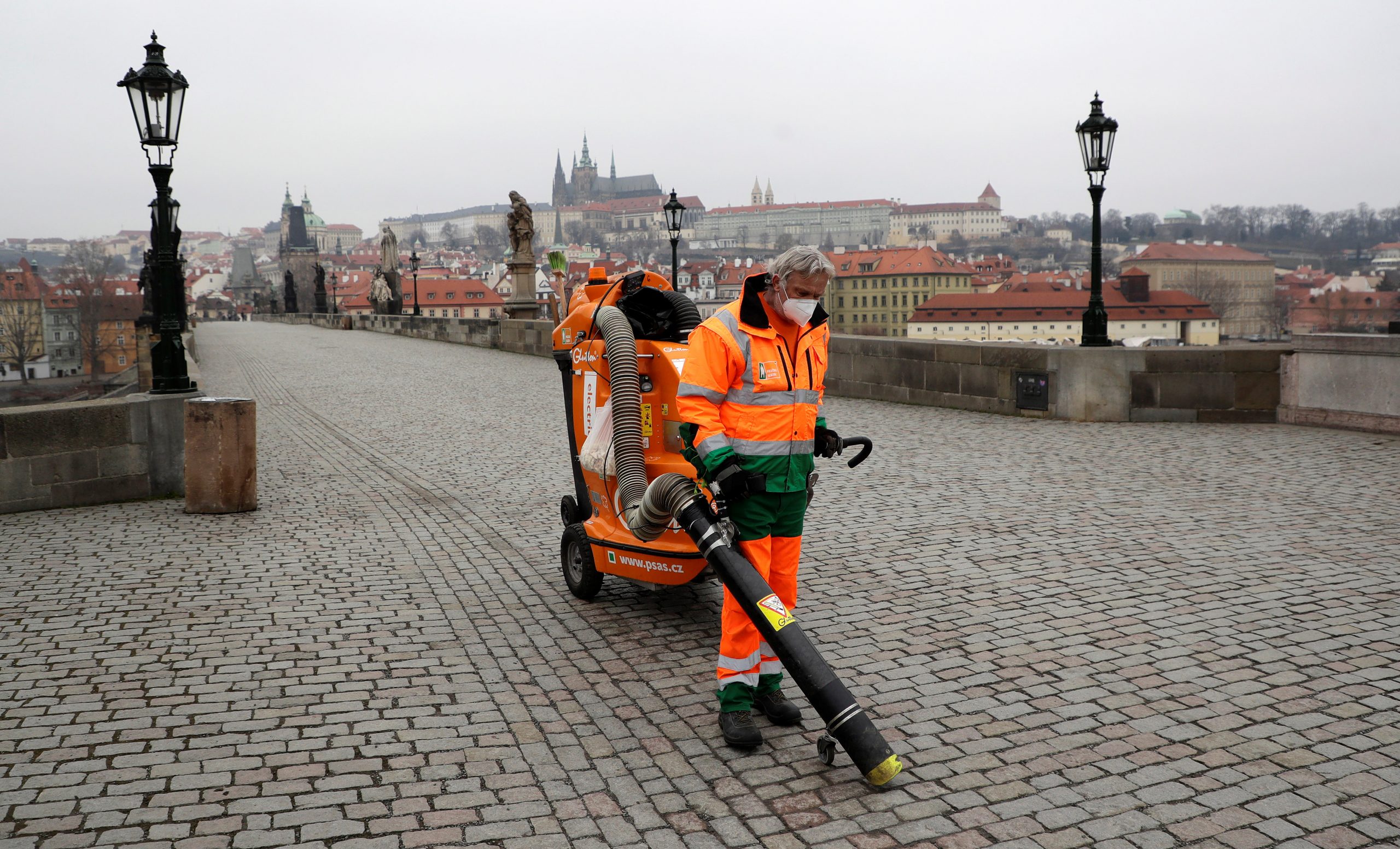 01032021 A man wearing a face mask cleans the empty Charles Bridge as the Czech government mandated further restrictions to curb the spread of the coronavirus disease (COVID-19) in Prague, Czech Republic, March 1, 2021.  REUTERS/David W Cerny