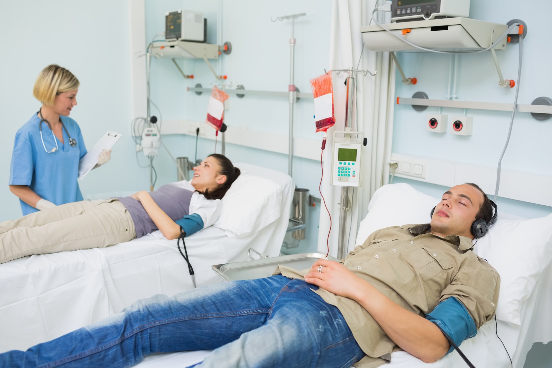 Patients lying on beds in hospital ward