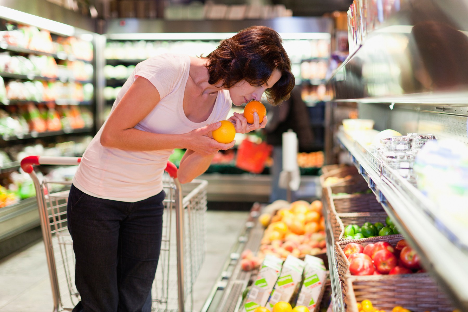 Woman smelling fruit at grocery store