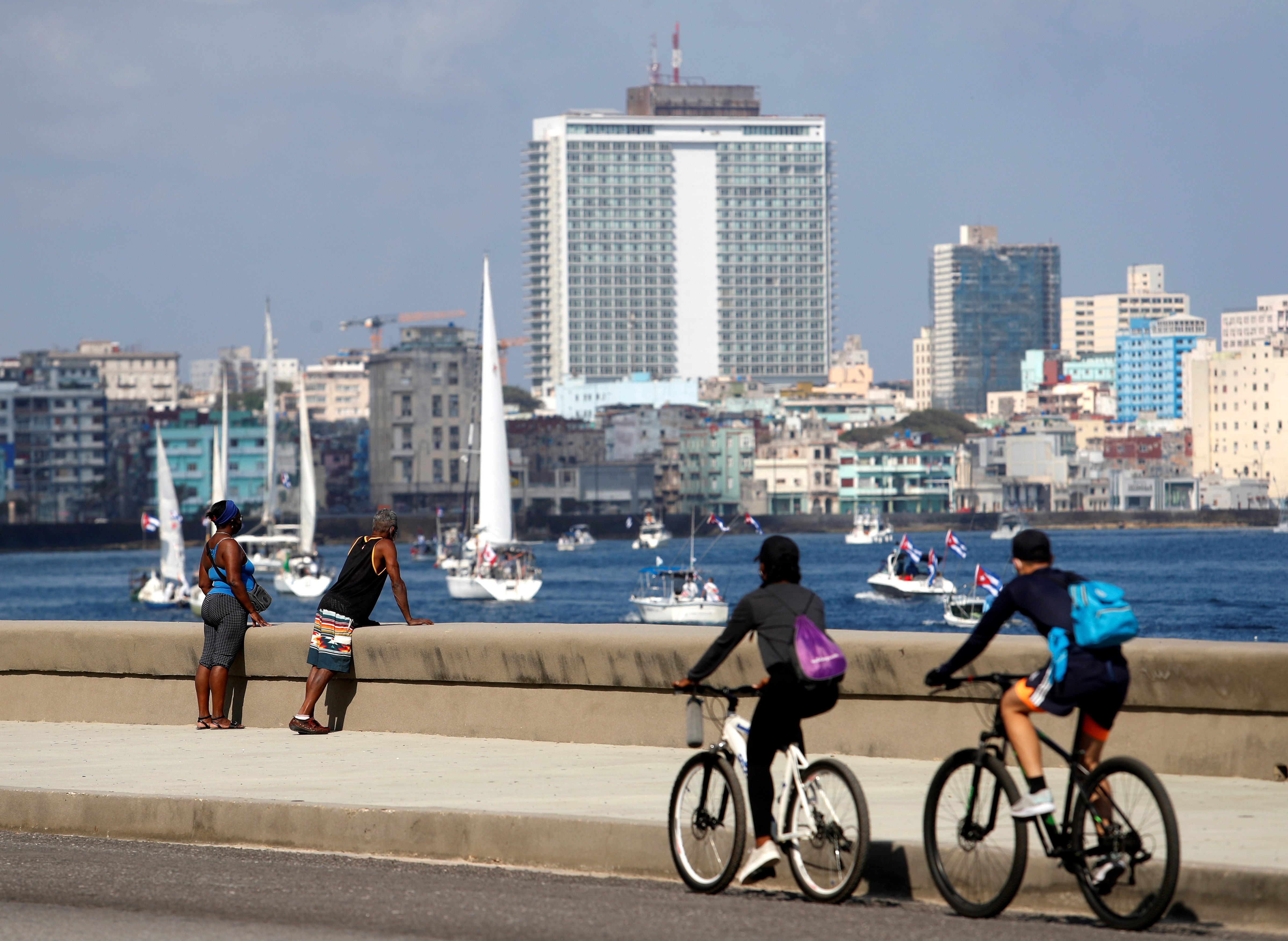 epa09158950 People observe the boats participating during a protest against the US blockade against Cuba, held on boats on the Malecon of Havana, Cuba, 25 April 2021.  EPA-EFE/Yander Zamora