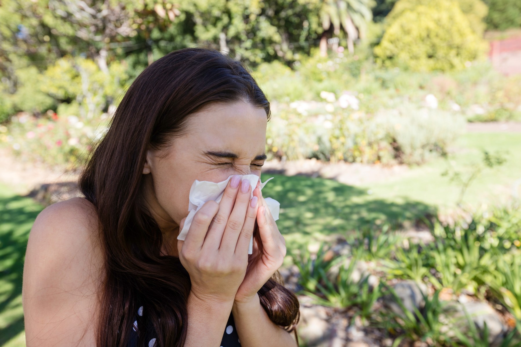 Woman blowing nose with tissue paper