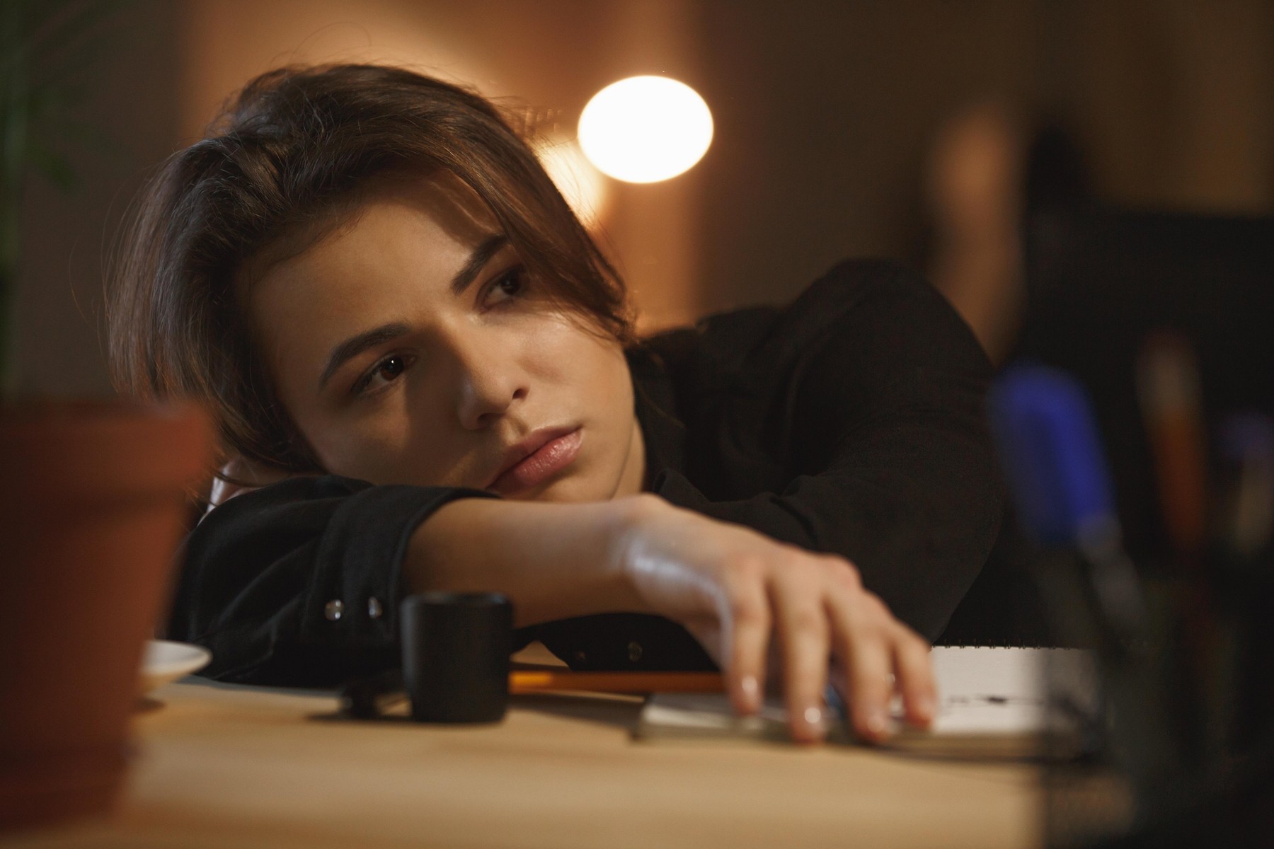 Tired young woman looking at monitor while working in office