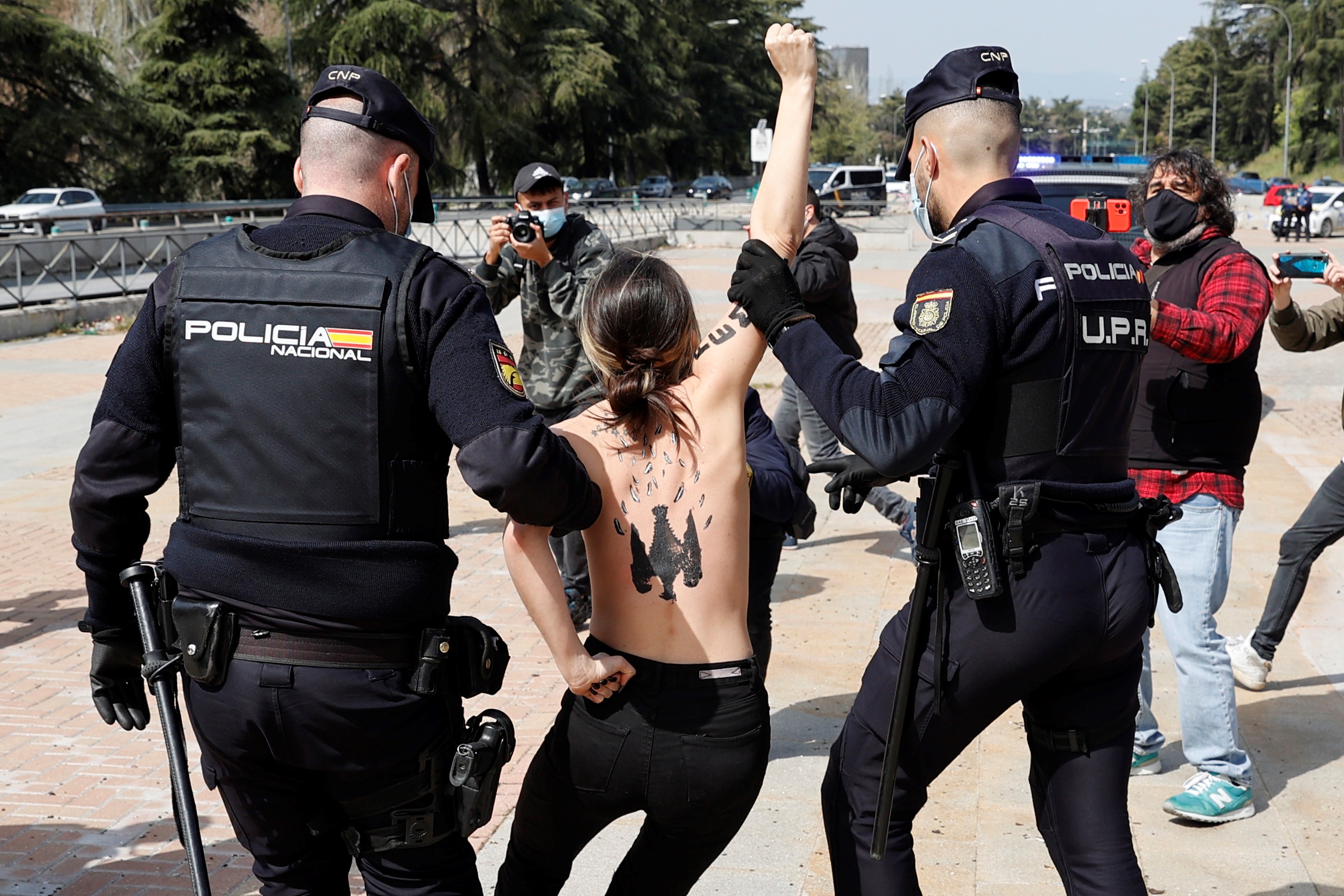 epa09102989 Policemen escort a Femen activist who broke into a rally of Franco's dictatorship regimen followers in Madrid, Spain, 28 March 2021.  EPA-EFE/Zipi