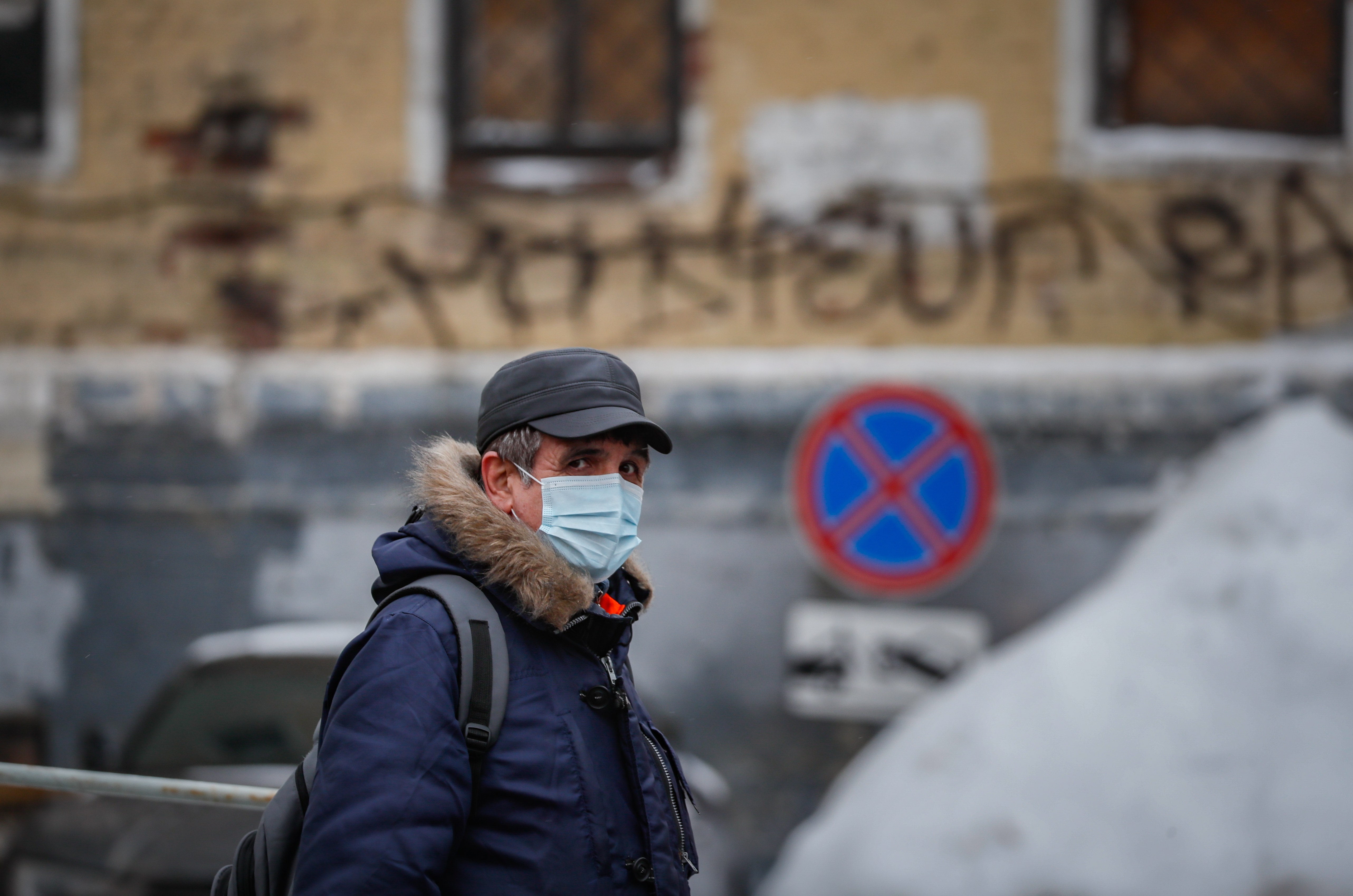 epa08931584 Russian man wearing a protective face mask walks on the street in center of Moscow, Russia, 11 January 2021 during the pandemic of SARS-CoV-2 coronavirus.  EPA-EFE/YURI KOCHETKOV