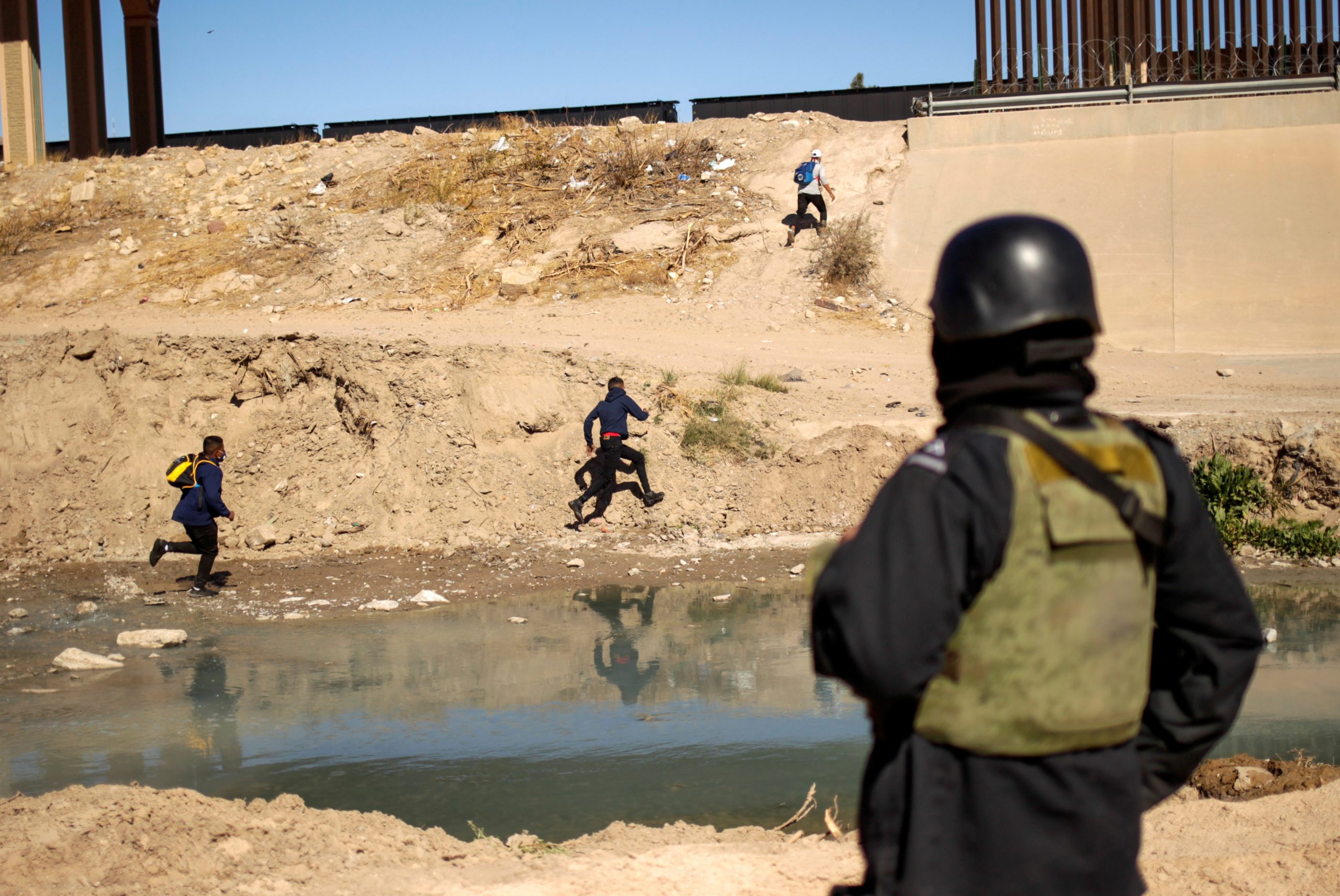 06022021 A member of the Mexican National Guard observes migrants after they crossed into El Paso, Texas, U.S., to turn themselves in to request asylum, as seen from Ciudad Juarez, Mexico February 5, 2021. REUTERS/Jose Luis Gonzalez