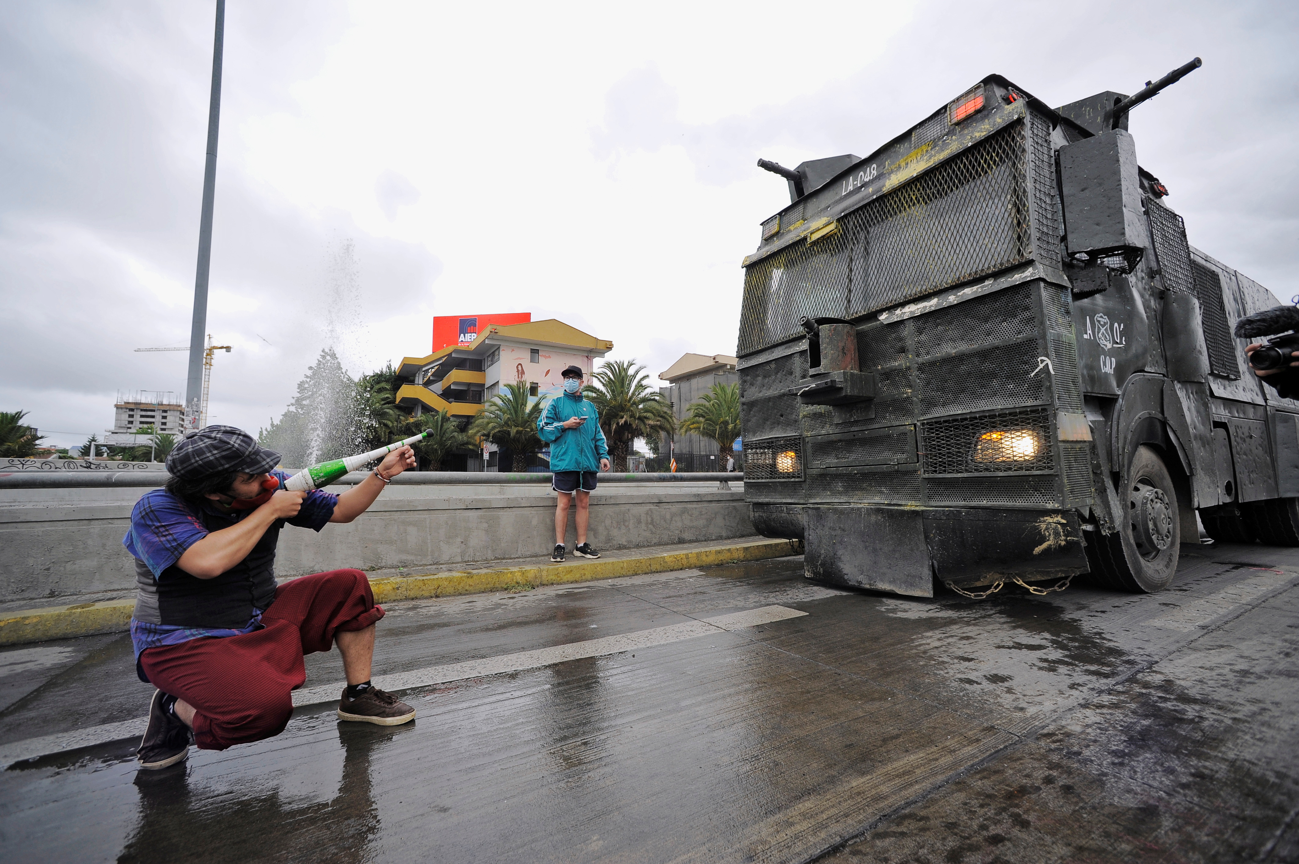 07022021 A street performer gestures toward a riot police vehicle during a protest after a police officer shot dead a street performer in the southern area of Panguipulli, in Concepcion, Chile, February 6, 2021. REUTERS/Jose Luis Saavedra