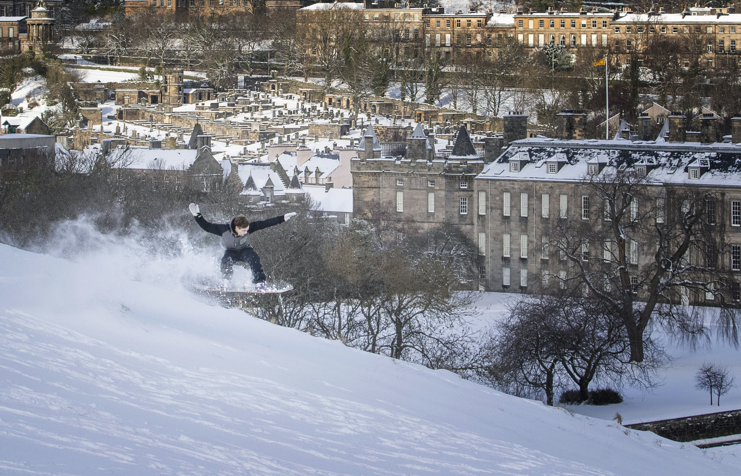 10022021 Kyle Hamilton snowboards down Saliisbury Crags in Holyrood Park, Edinburgh, Scotland, as the cold snap continues to grip much of the nation, Wednesday, Feb. 10, 2021. (Jane Barlow/PA via AP)