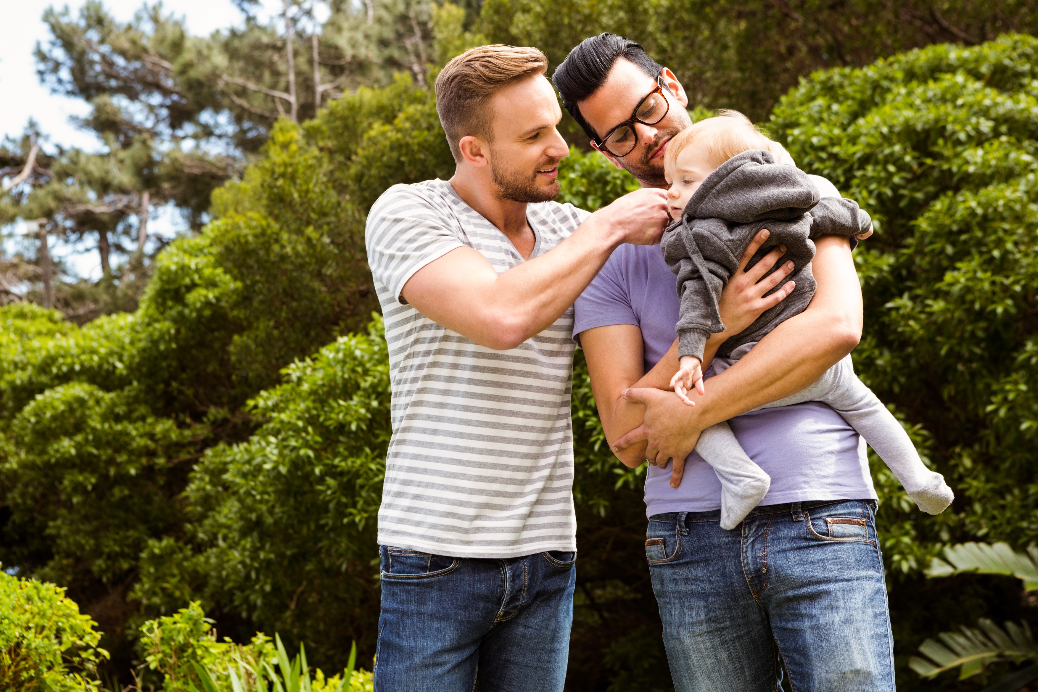 Smiling gay couple with child in garden,Image: 279970681, License: Royalty-free, Restrictions: , Model Release: yes, Credit line: - / Wavebreak / Profimedia