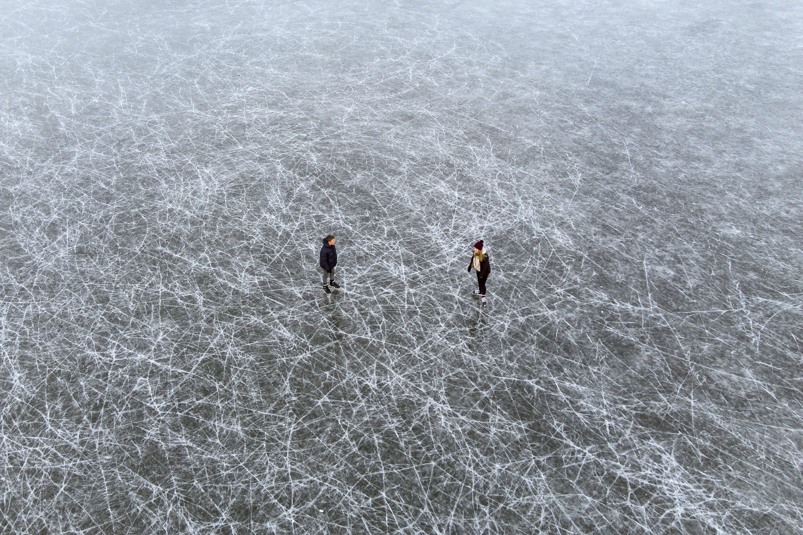 People ice skate on frozen flooded fields near Ely in Cambridgeshire, as the cold snap continues to grip much of the nation, in England, Sunday, Feb. 14, 2021. (Joe Giddens/PA via AP)